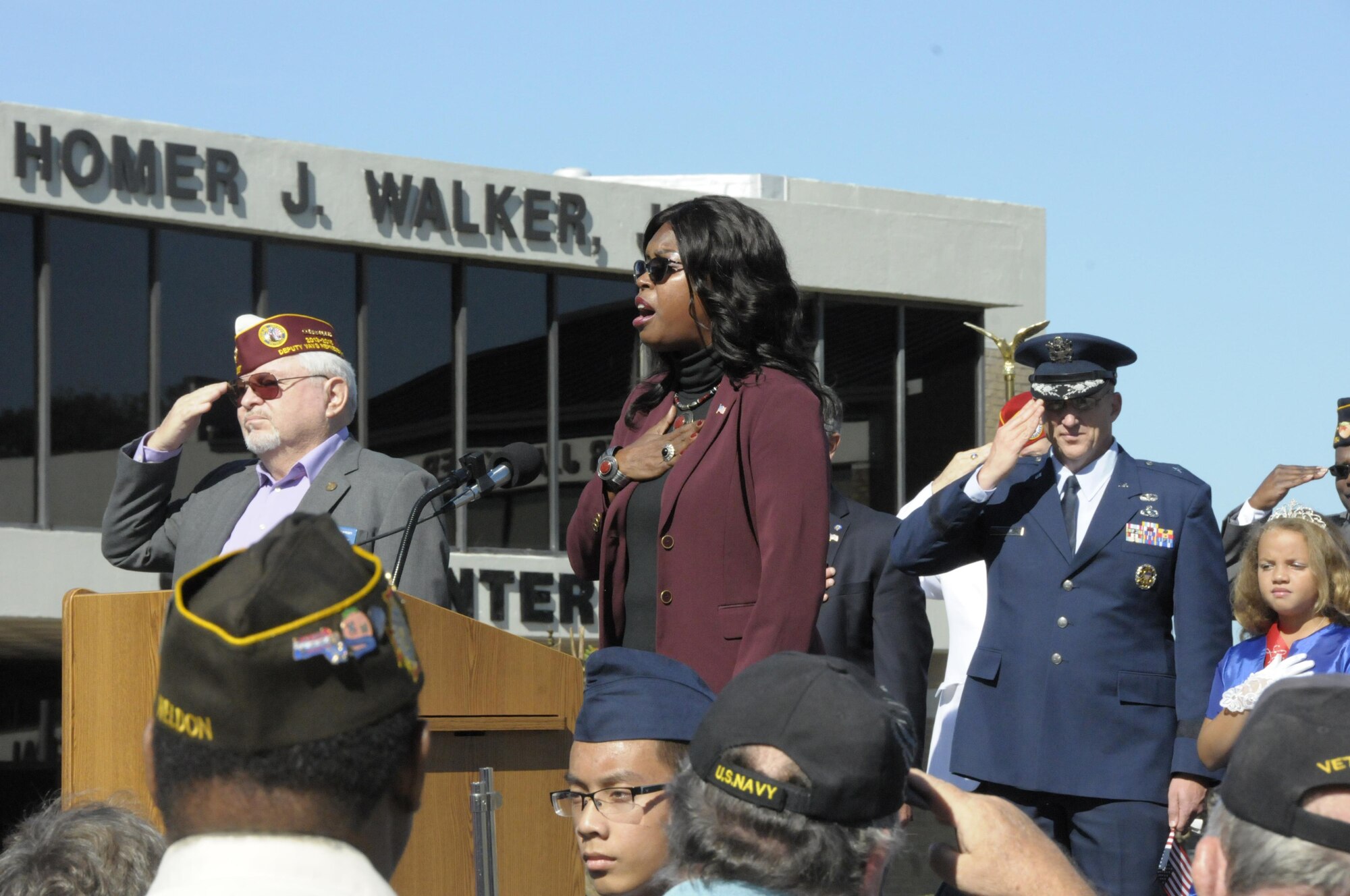 Diana Vining sings the National Anthem during the Warner Robins Veteran’s Day observance at City Hall Nov. 11. Brig. Gen. John Hickok, right, deputy director of Logistics, Engineering and Force Protection at Headquarters, Air Force Reserve Command, attended on behalf of the command. (U.S. Air Force photo/Robert Helton)