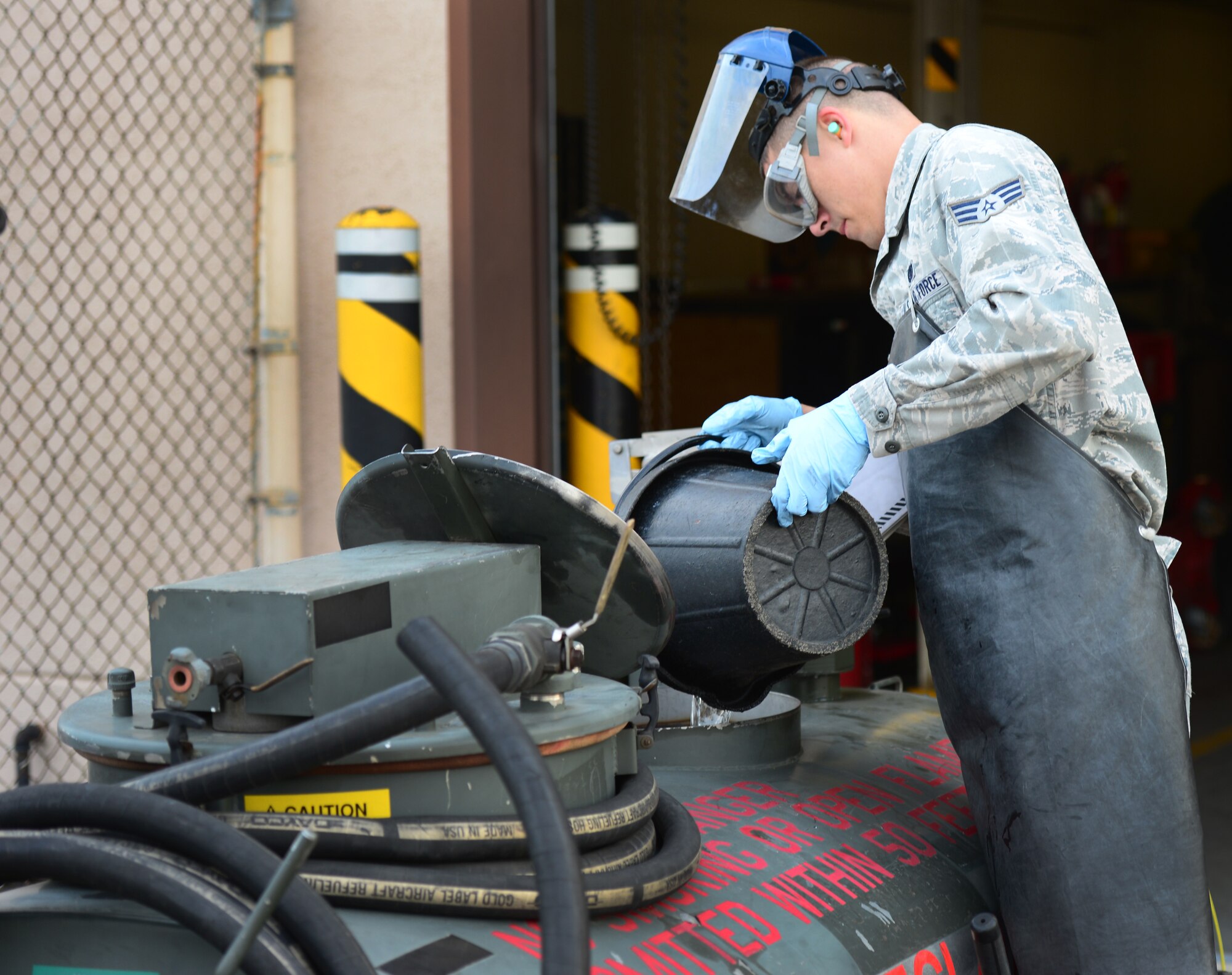 Senior Airman Joshua Jordan, 51st Logistic Readiness Squadron preventive maintenance technician, pours a bucket of JP-8 jet fuel into a fuel recovery unit at Osan Air Base, Republic of Korea, Oct. 15, 2015. Gallons of fuel are drawn every day in order to sample for sediment contaminants and excess water. (U.S. Air Force photo/Staff Sgt. Amber Grimm)