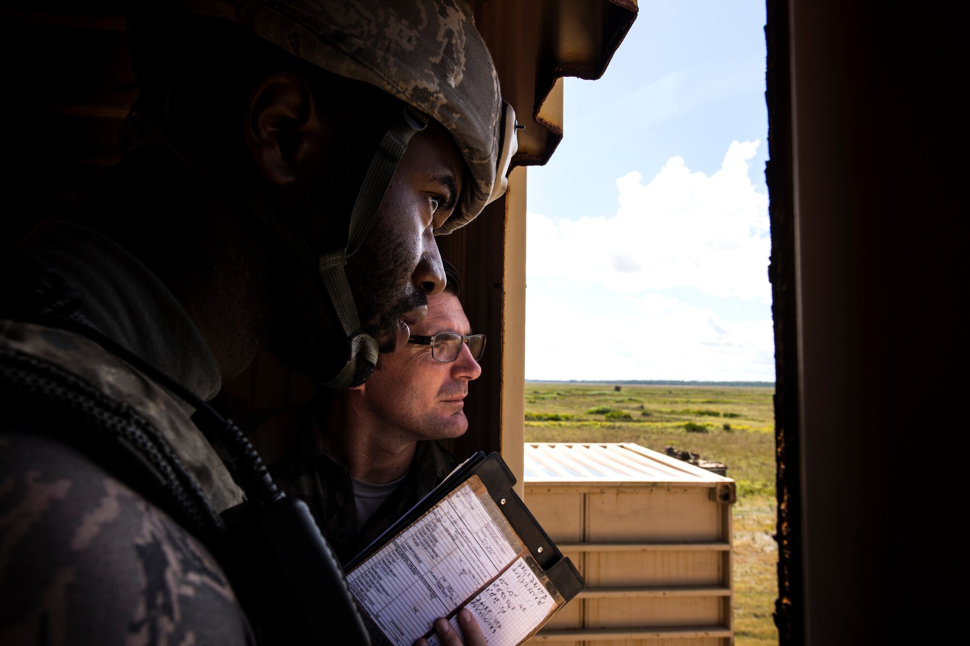 U.S. Air Force Staff Sgt. Marcus McComb, foreground, 822nd Base Defense Squadron fireteam leader, and French air force Adjutant Le Du look through a window during emergency close air support procedure training during exercise GLOBAL EAGLE, Oct. 29, 2015, at Avon Park Air Force Range, Fla. During the ECAS training, the Airmen practiced directing a pilot onto a target using visual descriptions and cardinal directions. (U.S. Air Force photo by Senior Airman Ryan Callaghan/Released)
