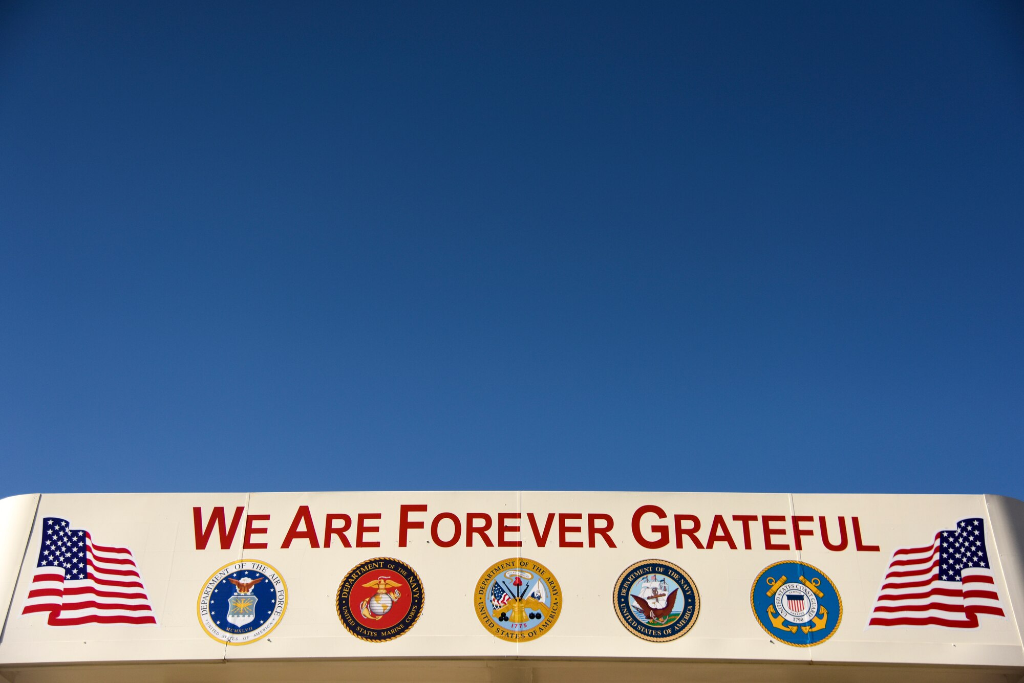 A sign is displayed over a local business during the annual Veterans’ Day Parade, Nov. 11, 2015, in downtown Goldsboro, North Carolina. The sign represents the community’s enduring support of service members, both past and present. (U.S. Air Force photo/Senior Airman Brittain Crolley)