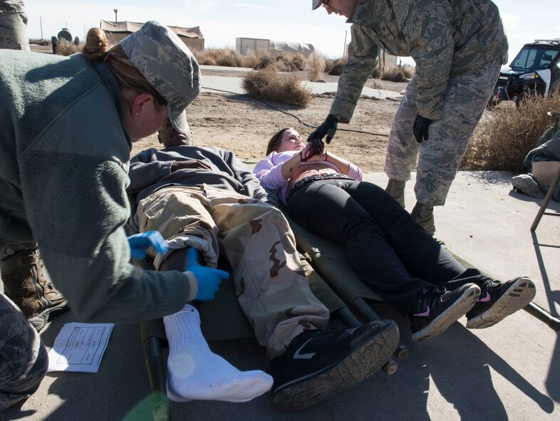 Personnel from a surgical team evaluate simulated injuries during Gunfighter Flag 16-1 at Mountain Home Air Force Base, Idaho, Nov. 5, 2015. Airmen volunteered to be moulaged to create realistic simulated injuries. (U.S. Air Force photo by Airman 1st Class Jessica H. Evans/RELEASED)