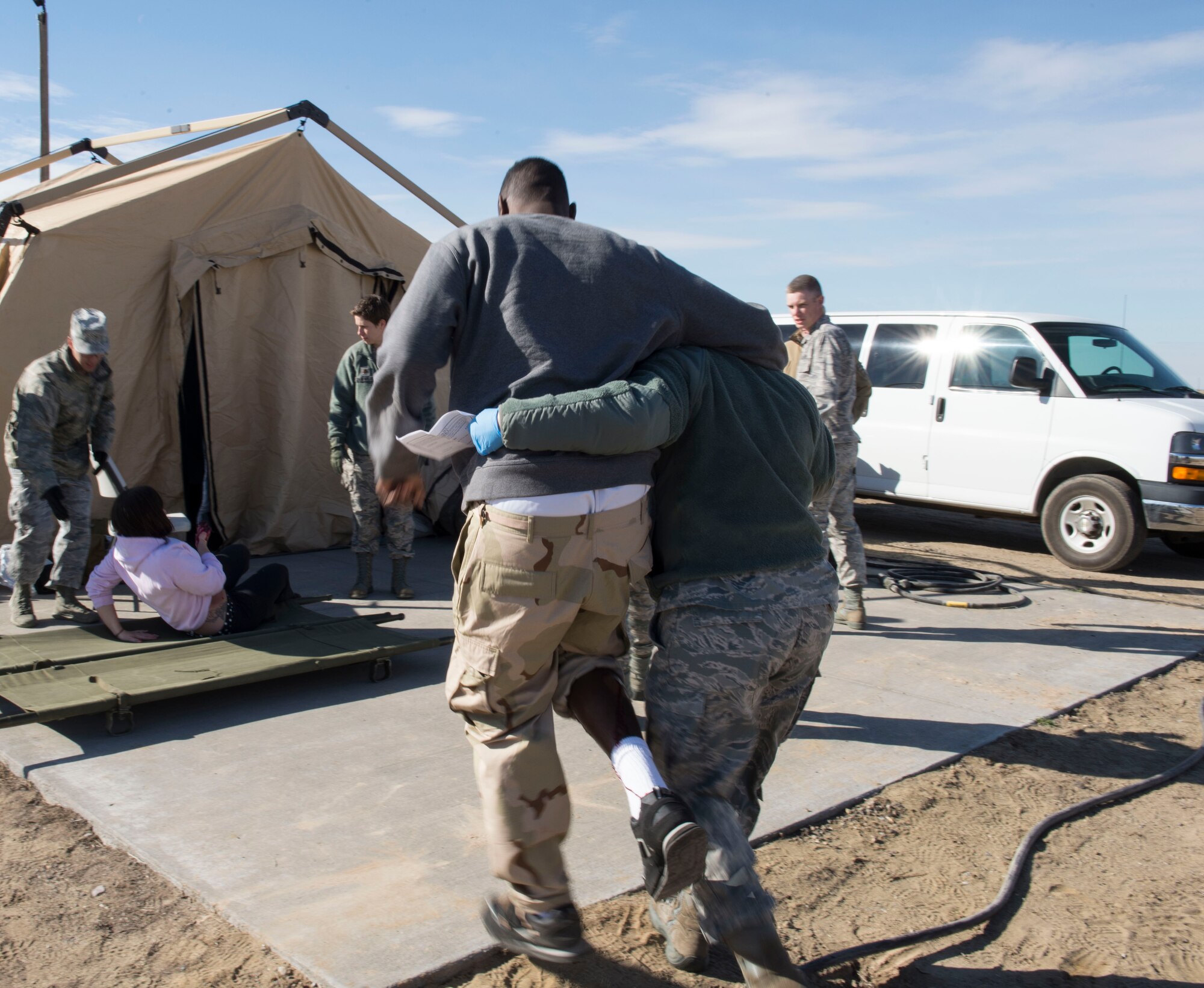 Capt. Amanda Roby, operating room nurse with the 141st Medical Group helps Airman 1st Class Kevin Joseph, aerospace medical technician from the 366th Medical Operations Squadron, walk to a safe place for his simulated evaluation at Mountain Home Air Force Base, Idaho, Nov. 5, 2015. Joseph volunteered to act as an injured patient during the Gunfighter Flag 16-1 exercise. (U.S. Air Force photo by Airman 1st Class Jessica H. Evans/RELEASED)