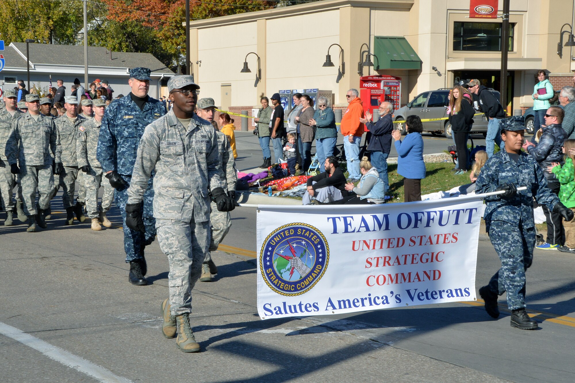 U.S. Navy Rear Adm. Steven L. Parode, the U.S. Strategic Command Director of Intelligence, leads the STRATCOM troops down Mission Avenue in Bellevue, Neb., to kick off the 15th annual Veterans Day Parade Nov. 7, 2015. U.S. Air Force Senior Airman Cedric M. Gibson and U.S. Navy Yeoman Seaman Lisa Walton, both of STRATCOM, carried the STRATCOM banner. (U.S. Air Force photo by D.P. Heard)
