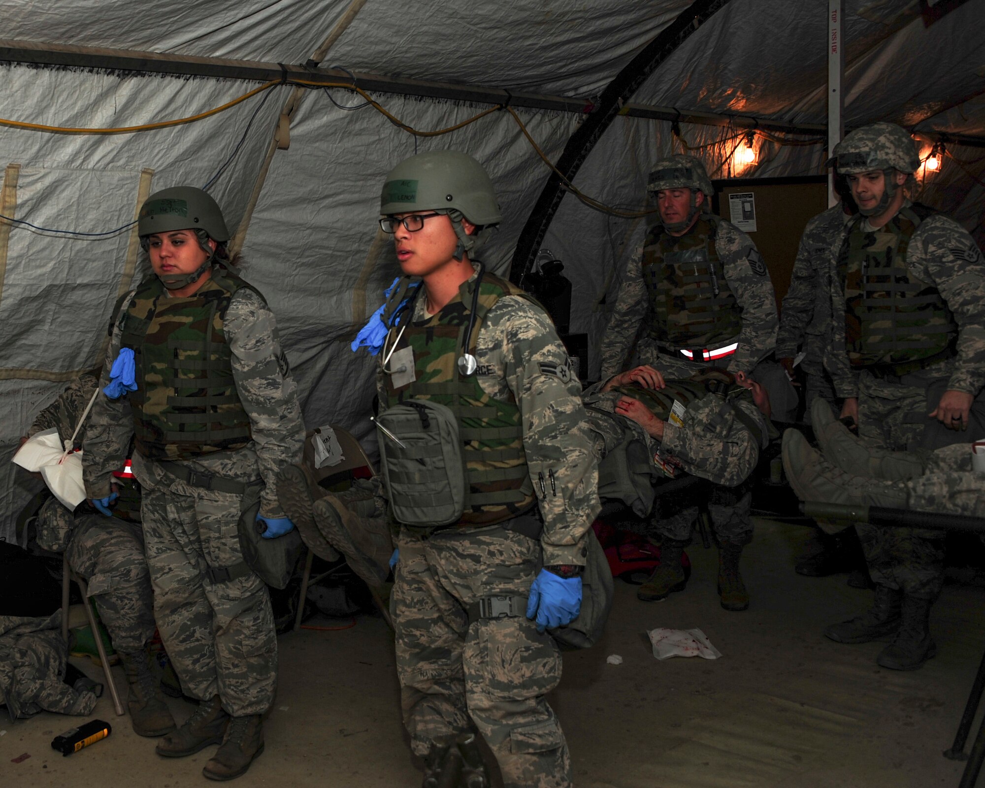 U.S. Airmen transport a simulated casualty during Exercise BUSHWHACKER 15-07 at Davis-Monthan Air Force Base, Ariz., Nov. 5, 2015. During the exercise, Airmen acted as patients and used moulage to create a realistic experience, allowing medical Airmen to perceive the wounds they were treating. (U.S. Air Force photo by Airman Basic Nathan H. Barbour/Released)