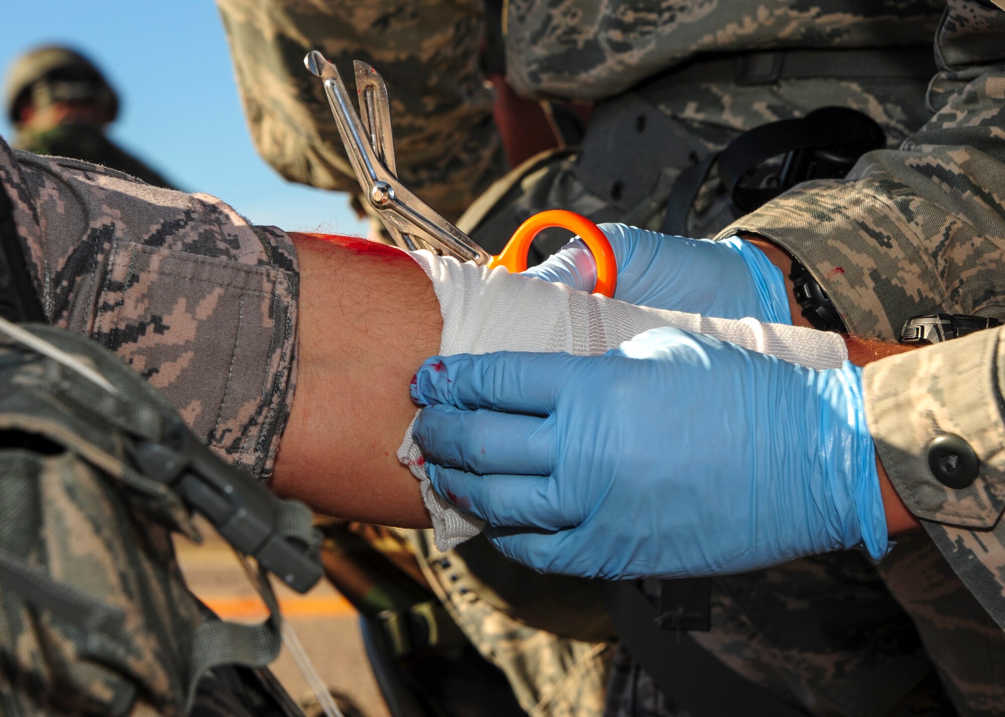 A U.S. Airman treats a simulated wound during Exercise BUSHWHACKER 15-07 at Davis-Monthan Air Force Base, Ariz., Nov. 5, 2015. During the exercise, Airmen acted as patients and used moulage to create a realistic experience, allowing medical Airmen to perceive the wounds they were treating. (U.S. Air Force photo by Airman Basic Nathan H. Barbour/Released)