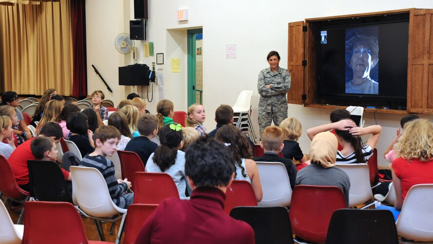 Maj. Andrea Pitruzzella, Chief of Public Affairs, 914th Airlift Wing, assists with a video presentation by Master Sgt. Kevin Nichols (on screen), superintendent, 386th Air Expeditionary Wing Public Affairs at Hoover Elementary School in Tonawanda, N.Y. on Nov. 9, 2015. Nichols is assigned to the 914 AW and is currently deployed overseas in support of Operation Inherent Resolve.  (U.S. Air Force photo by Staff Sgt. Matthew Burke)