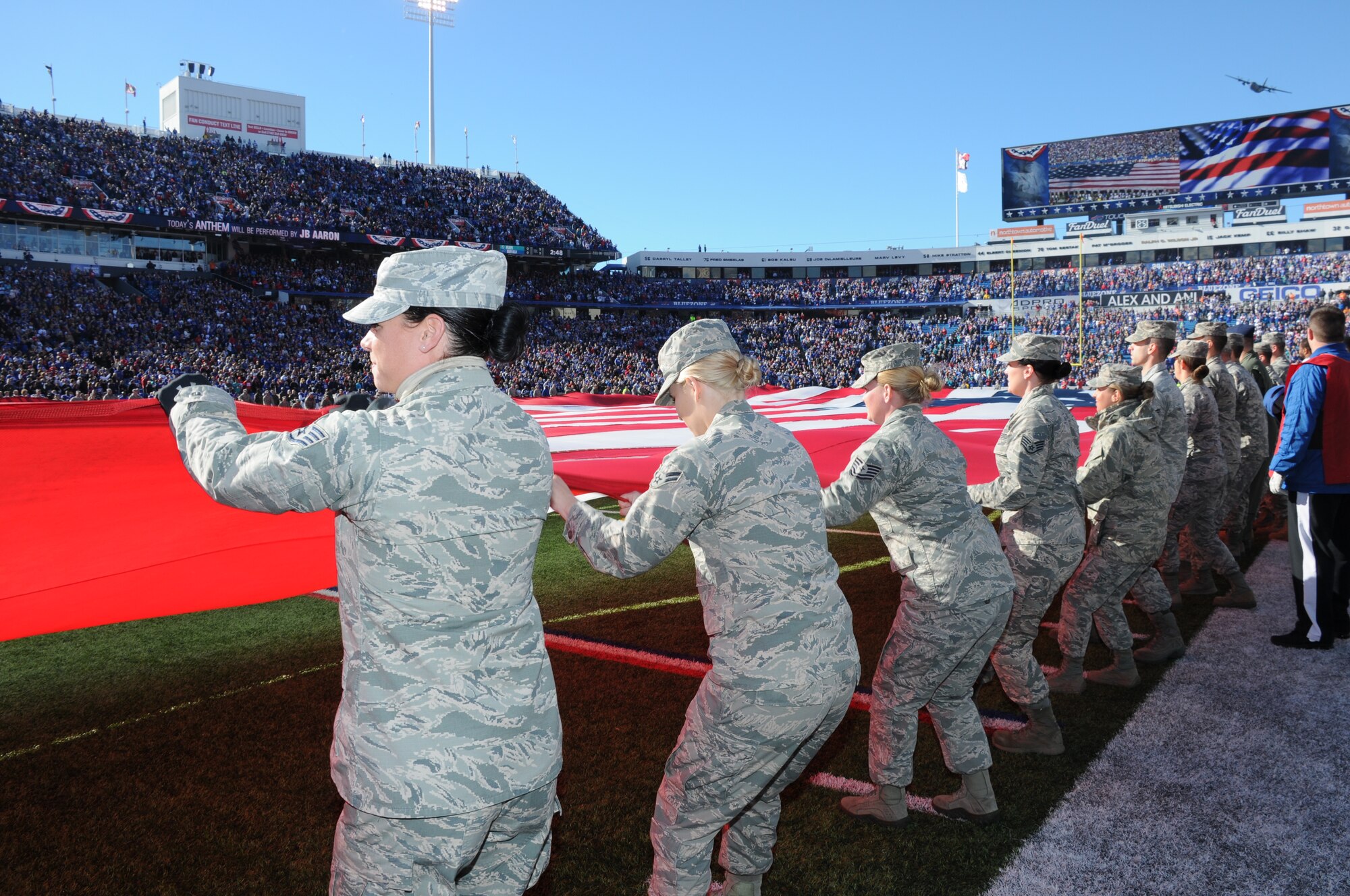 Military personnel from the Western New York community hold a flag during the national anthem on Nov. 8, 2015 at Ralph Wilson Stadium in Orchard Park, N.Y. The ceremony also included a pregame introduction and a flyover of a C-130 Hercules from the 328th Airlift Squadron. (U.S. Air Force photo by Staff Sgt. Matthew Burke)