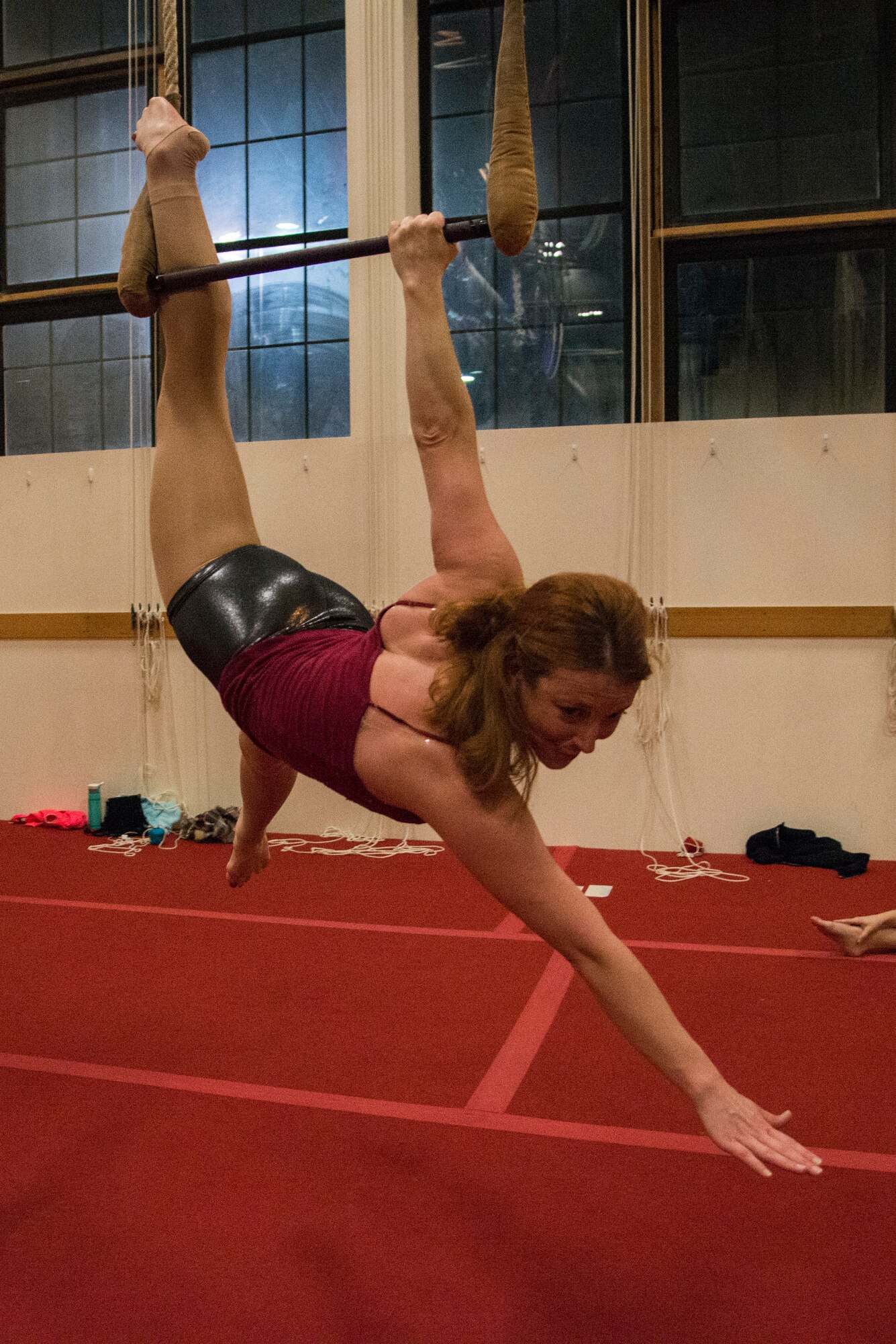 Maj. Melody Jones, Wing Intelligence Chief of the 375th Operations Support Squadron, performs during a showcase at Bumbershoot Aerial Arts Studio in St. Louis. Trapeze is an apparatus, used in gymnastics, acrobatics, and aerial arts, consisting of a short horizontal bar attached to the ends of two suspended ropes. (U.S. Air Force photo by Airman Gwendalyn Smith)