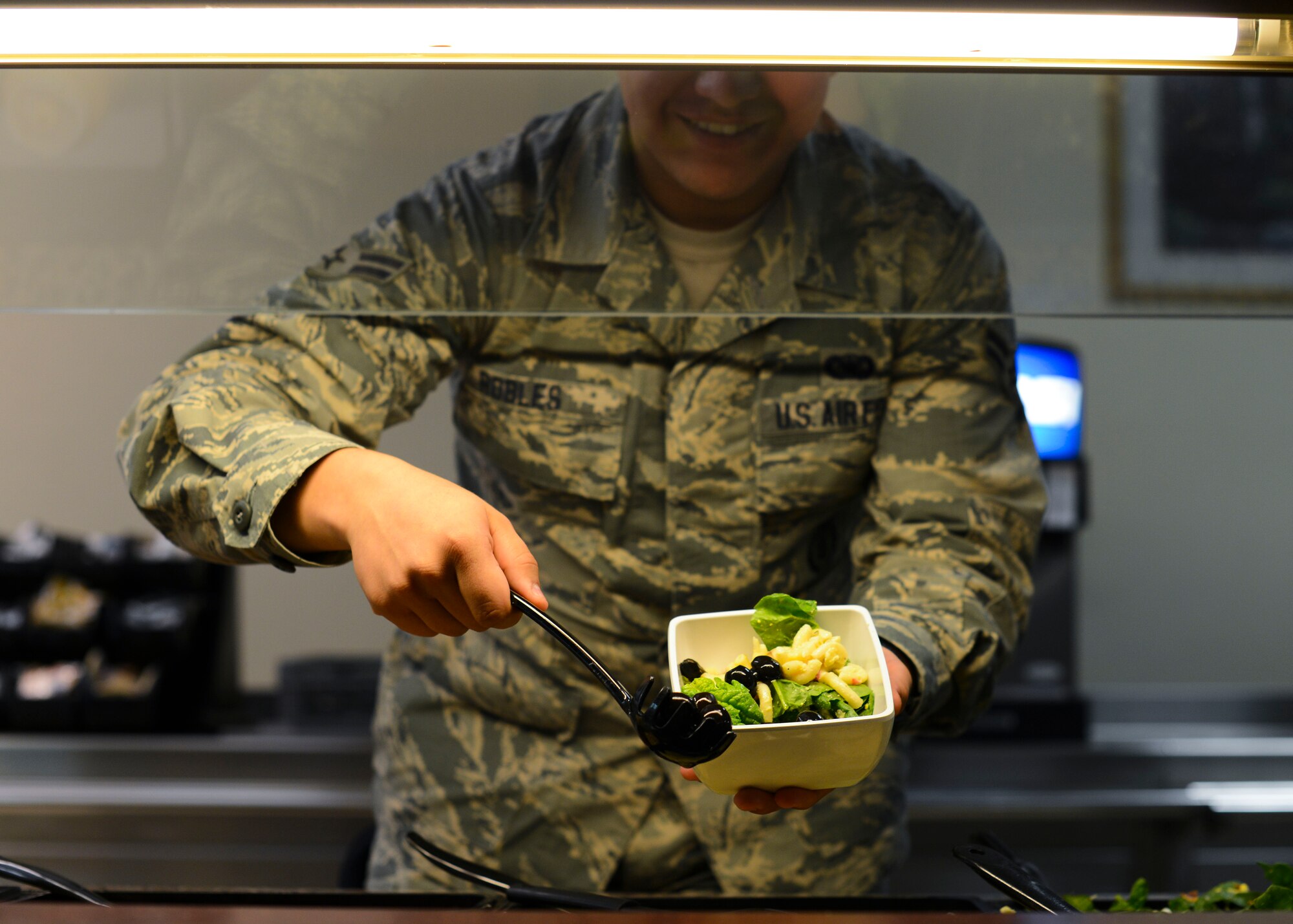 U.S. Air Force Airman 1st Class Rafael Robles, 31st Security Forces Squadron security response team member, makes a salad, Nov. 10, 2015, at Aviano Air Base, Italy. An updated serving line is scheduled to open Nov. 27 at the La Dolce Vita dining facility, which is the first of many beautification projects there. (U.S. Air Force photo by Senior Airman Austin Harvill/Released)