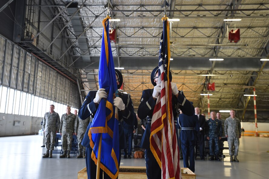 Team Andrews Airmen stand at attention while base honor guard dress the U.S. and Air Force flags during a ground breaking ceremony for the 811 Operations Group at Joint Base Andrews, Md., Nov. 12, 2015. The new facility will provide space for mission planning, briefing, training, flight simulation, operations and administration. (U.S. Air Force photo by Senior Airman Joshua R. M. Dewberry/Released)
