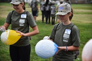 Azlynn Mims, daughter of Capt. Raymond Mims from the 11th Wing Staff Agency, shaves shaving cream off a balloon to mimic the haircuts given to basic training trainees, Nov. 7, 2015, on Joint Base Andrews, Md. The event included physical training, a mock military in-processing station, basic drills and military knowledge classes, a survival class and capture the flag to help military children better understand and appreciate parental military service. (U.S. Air Force photo/ Airman 1st Class J.D. Maidens/ Released)