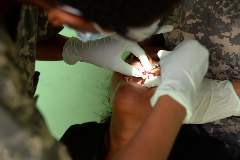 U.S. Army Capt. Mellissa Davis, dentist, prepares to pull a decayed tooth from a woman during a medical readiness training exercise, San Jose De Rio Pinto, Honduras, Nov. 12, 2015. The MEDRETES Joint Task Force-Bravo participates in are cooperative efforts with the ministries of health and various other organizations in the Central American nations, providing the task force members with valuable training while supplementing local healthcare capabilities. (U.S. Air Force Photo by Senior Airman Westin Warburton/Released)