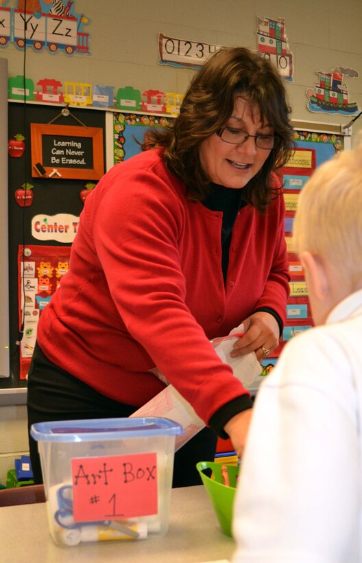Paula Carrelli, volunteer with the Horsham Air Guard Station Airman & Family Readiness Center, Pennsylvania, hands out art supplies to kindergarten students from Mary, Mother of the Redeemer Catholic School in North Wales, Pennsylvania, Nov. 12, 2015. 111th Attack Wing members and associated Wing civilian volunteers partnered with the school in an event intended help students develop into moral, civic, and good-mannered community members. (U.S. Air National Guard photo by Tech. Sgt. Andria Allmond/Released)
