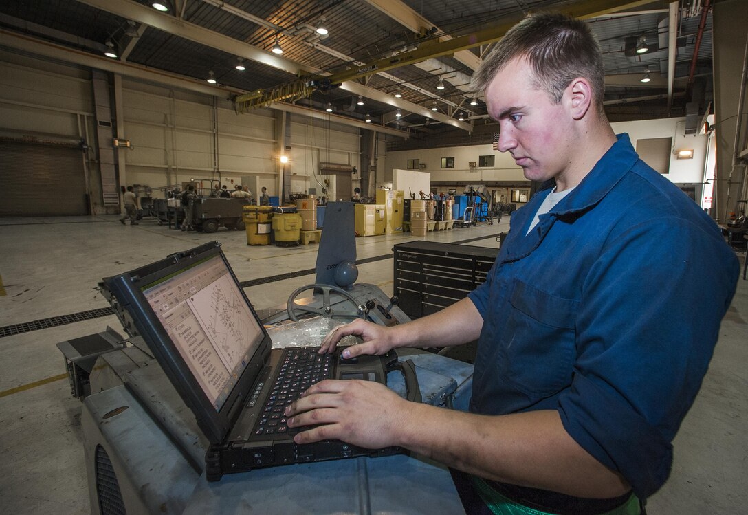 Senior Airman Nicholas Appenzeller, 8th Maintenance Squadron aerospace ground equipment journeyman, checks his technical data as he performs maintenance on a bomb lift at Kunsan Air Base, Republic of Korea, Nov. 10, 2015. The AGE flight maintains equipment that tests, services and troubleshoots aircraft systems while the aircraft is on the ground. (U.S. Air Force photo by Staff Sgt. Nick Wilson/Released)