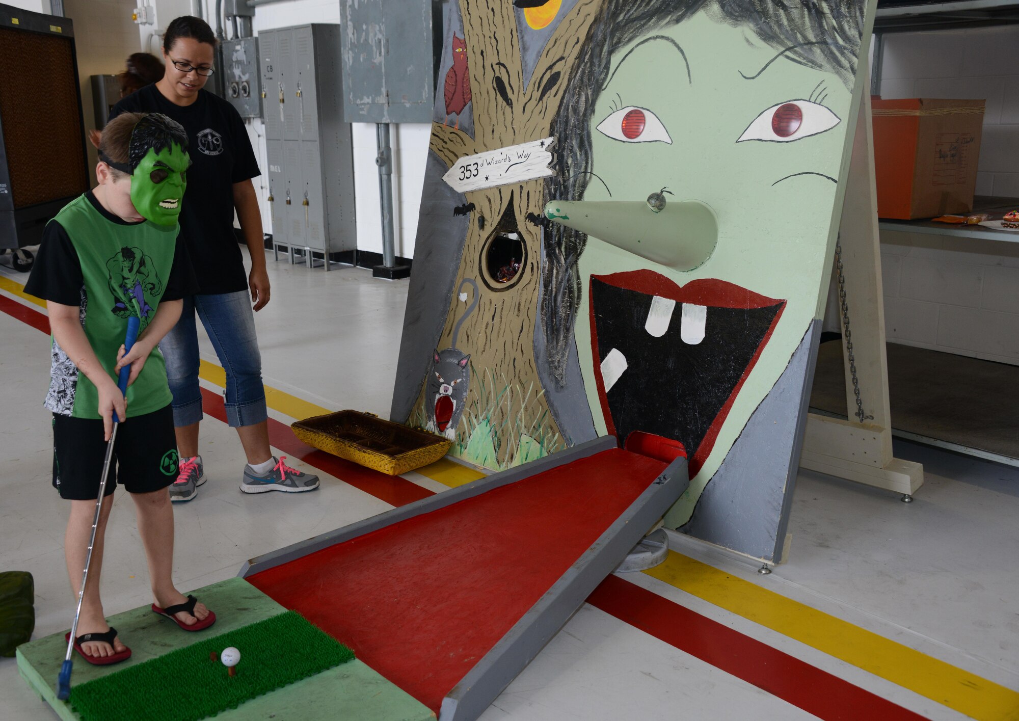 A child from the 353rd Special Operations Group attempts to make a hole in one during the 353rd Special Operations Group Fall Festival held Oct. 31, 2015 at Kadena Air Base, Japan.  All five squadrons from the 353rd Special Operations Group came together set up booths with games, activities and food for the children of the 353rd Special Operations Group.  (U.S. Air Force photo by Tech. Sgt. Kristine Dreyer)