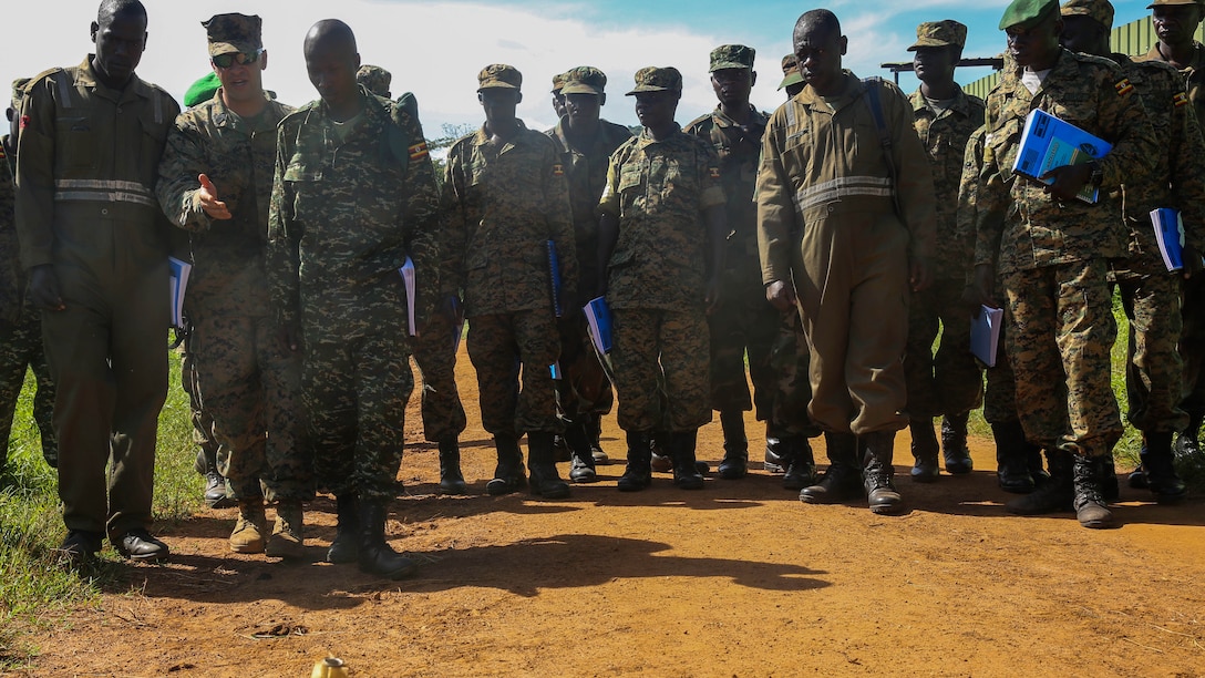 U.S. Marine Staff Sgt. Evan Crowgey, an explosive ordnance disposal technician with Special-Purpose Marine Air-Ground Task Force Crisis Response-Africa, explains how some obvious improvised explosive devices are used as a diversion during an IED awareness exercise with members of the Uganda People’s Defense Force Camp Singo, Uganda, Nov. 3, 2015. Marines and sailors with SPMAGTF-CR-AF are training with the UPDF to increase engineering and logistical capabilities while strengthening the bonds between the partner counties. 