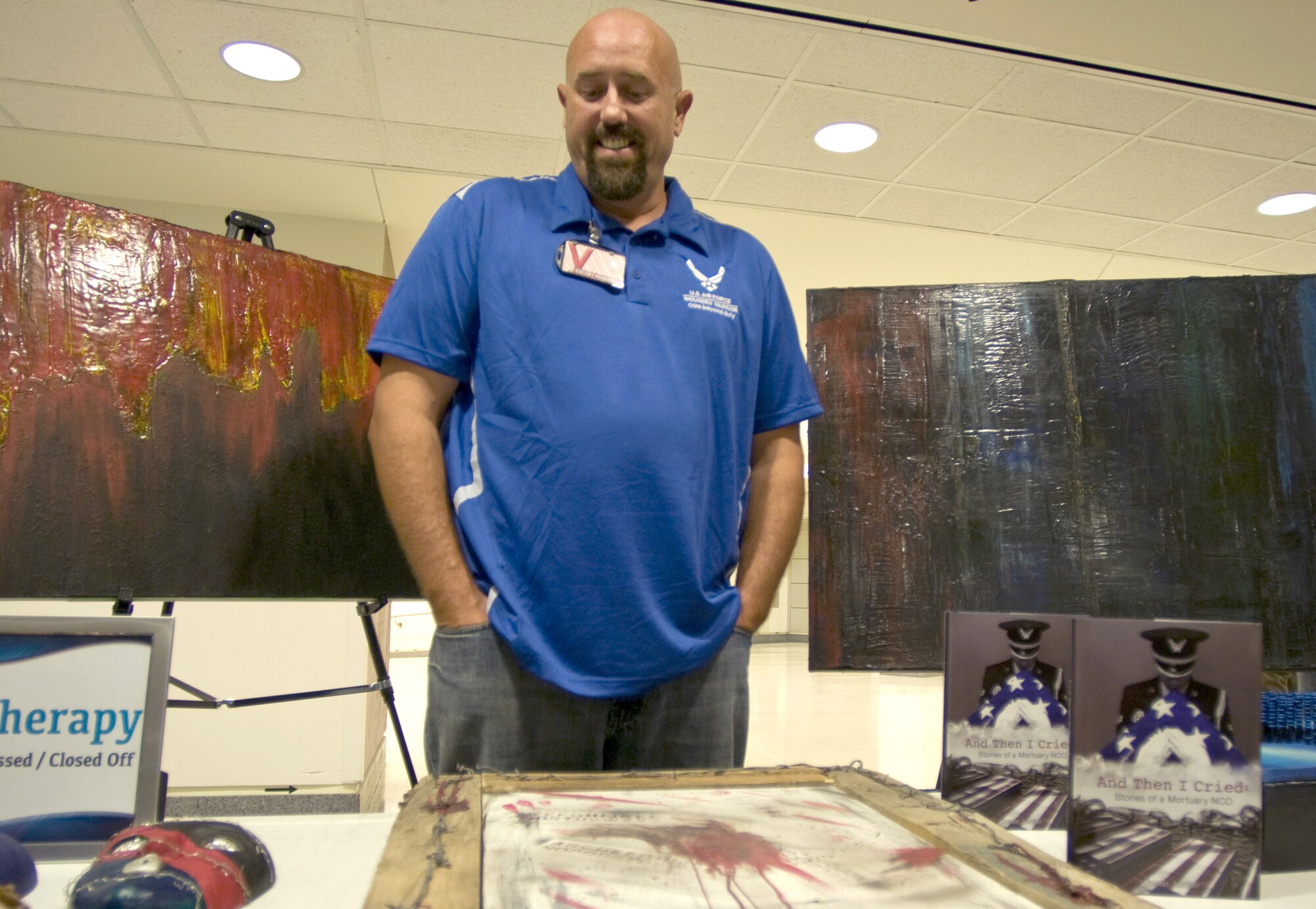 Retired Master Sgt. Justin Jordan looks over his artwork during a healing arts event Nov. 12 at the Pentagon. Jordan and other wounded military members were recognized for their work as part of a healing arts program created by the Defense Department and the National Endowment for the Arts to offer art therapy to recovering troops. (U.S. Air Force photo/Sean Kimmons)