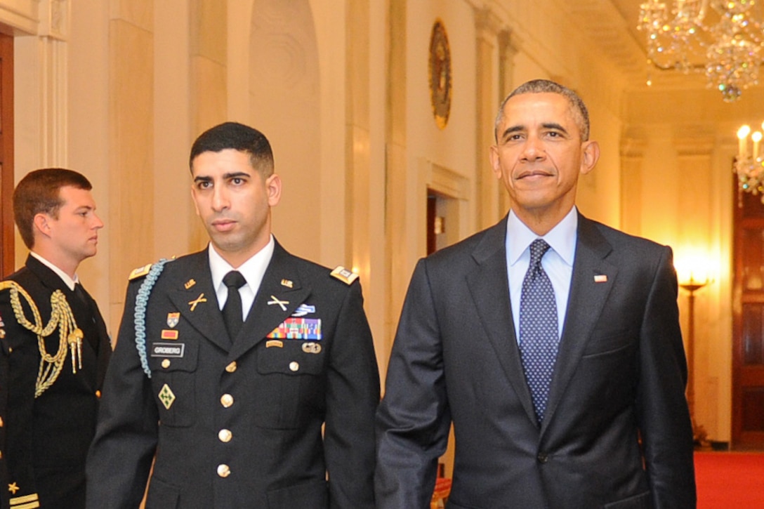 President Barack Obama escorts retired U.S. Army Capt. Florent Groberg to his Medal of Honor Ceremony at the White House in Washington, Nov. 12, 2015. Groberg received the medal for actions during a combat engagement in Kunar province, Afghanistan, Aug. 8, 2012, where he commanded a personal security detail for the 4th Infantry Division's 4th Brigade Combat Team. He and another soldier, Army Sgt. Andrew Mahoney, identified and tackled a suicide bomber, saving the lives of the brigade commander and several others. U.S. Army photo by Eboni L. Everson-Myart