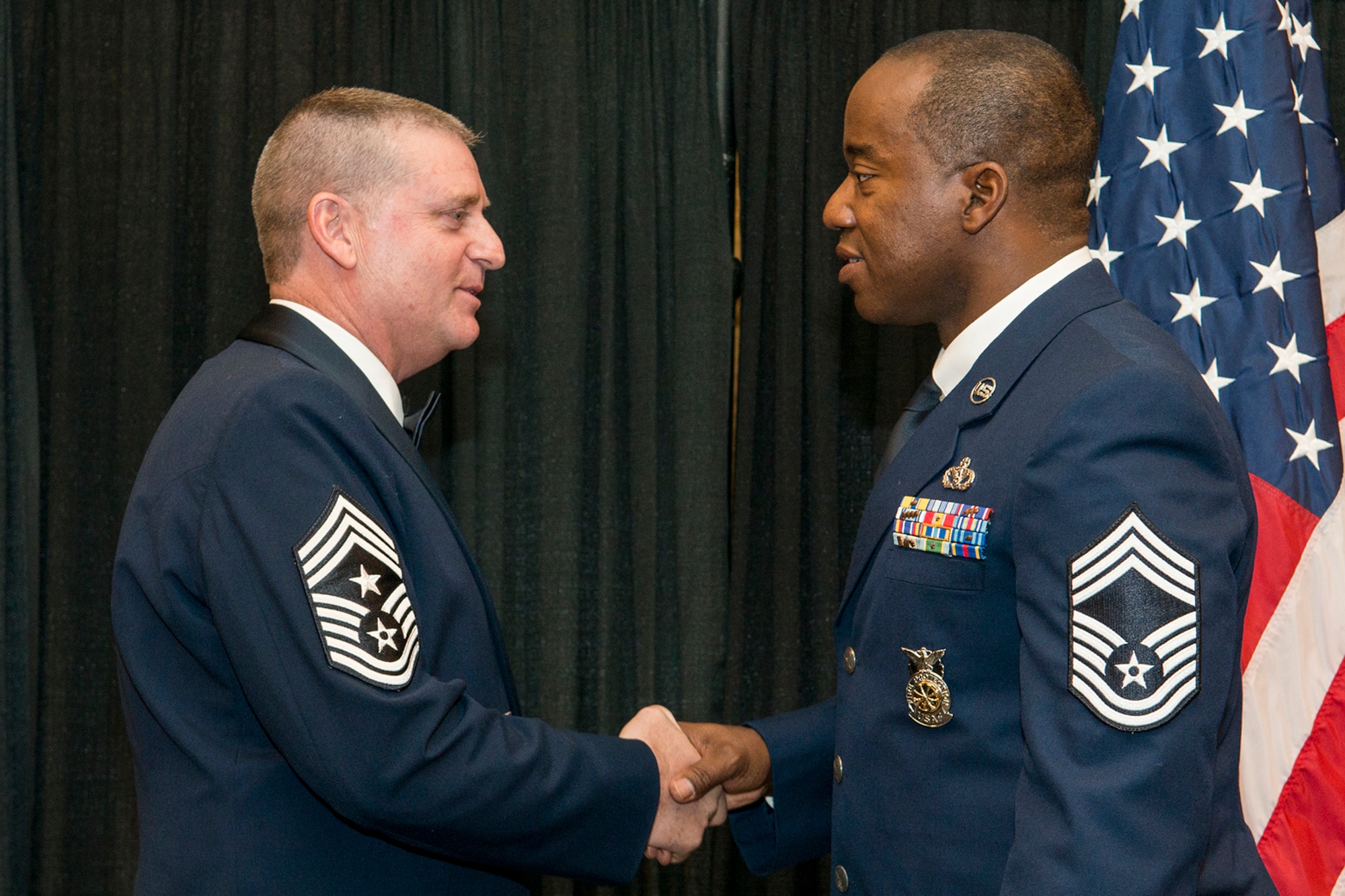 U.S. Air Force Chief Master Sgt. Randall Noble, 307th Bomb Wing Command Chief, congratulates recently promoted Chief Master Sgt. Jimmy Mobley during a ceremony on Nov. 7, 2015, Shreveport, La. The 307th Bomb Wing Senior Noncommissioned Officer Induction Ceremony is an annual event held to recognize Airmen who were recently promoted to the ranks of Chief Master Sergeant and Master Sergeant. (U.S. Air Force photo by Master Sgt. Greg Steele/Released)