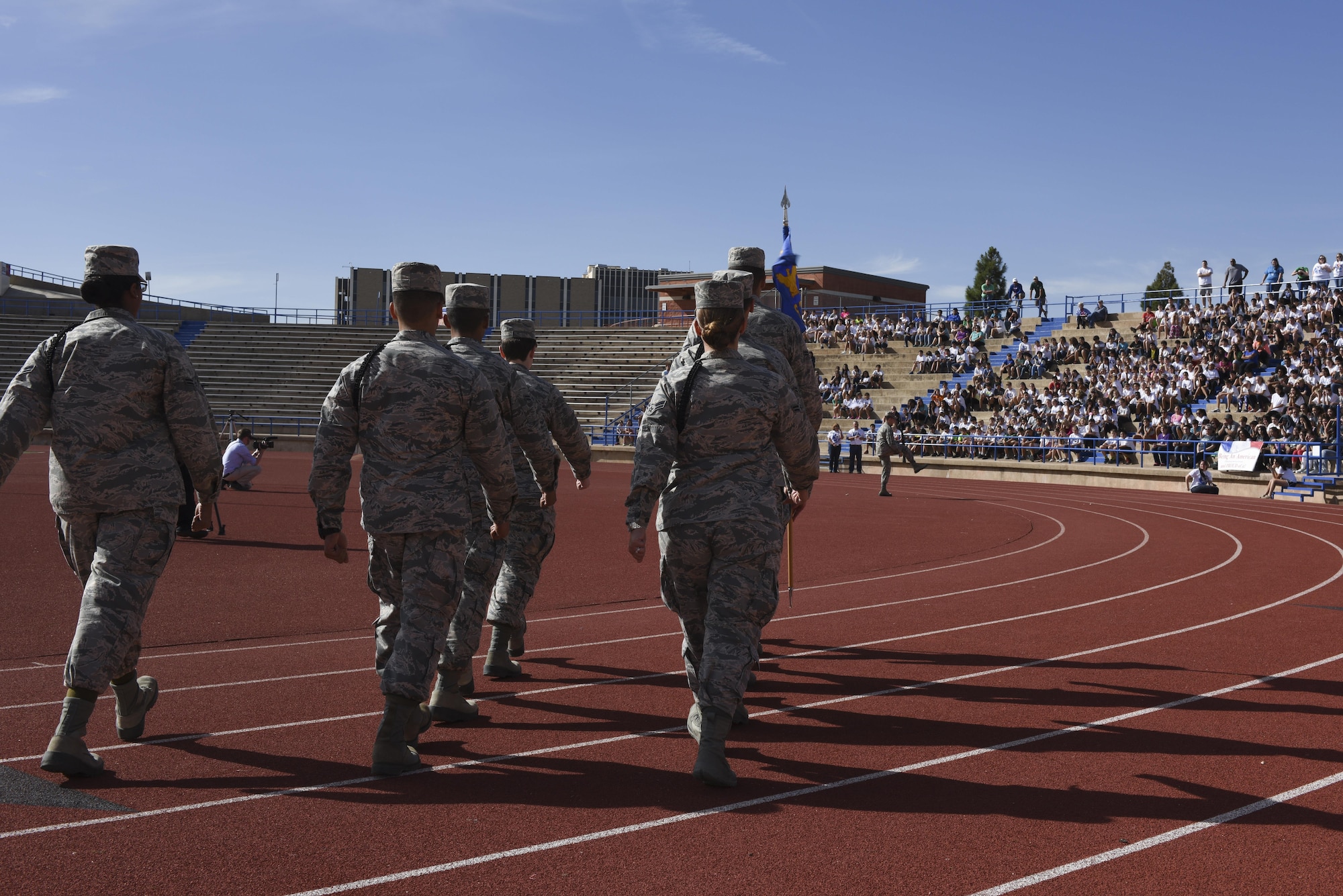 U.S. Air Force Airmen march in front of a crowd for the Take a Veteran to School event at the San Angelo Stadium in San Angelo, Texas, Nov. 11, 2015. The crowd gathered to show support for veterans. (U.S. Air Force photo by Airman Chase Sousa/Released)