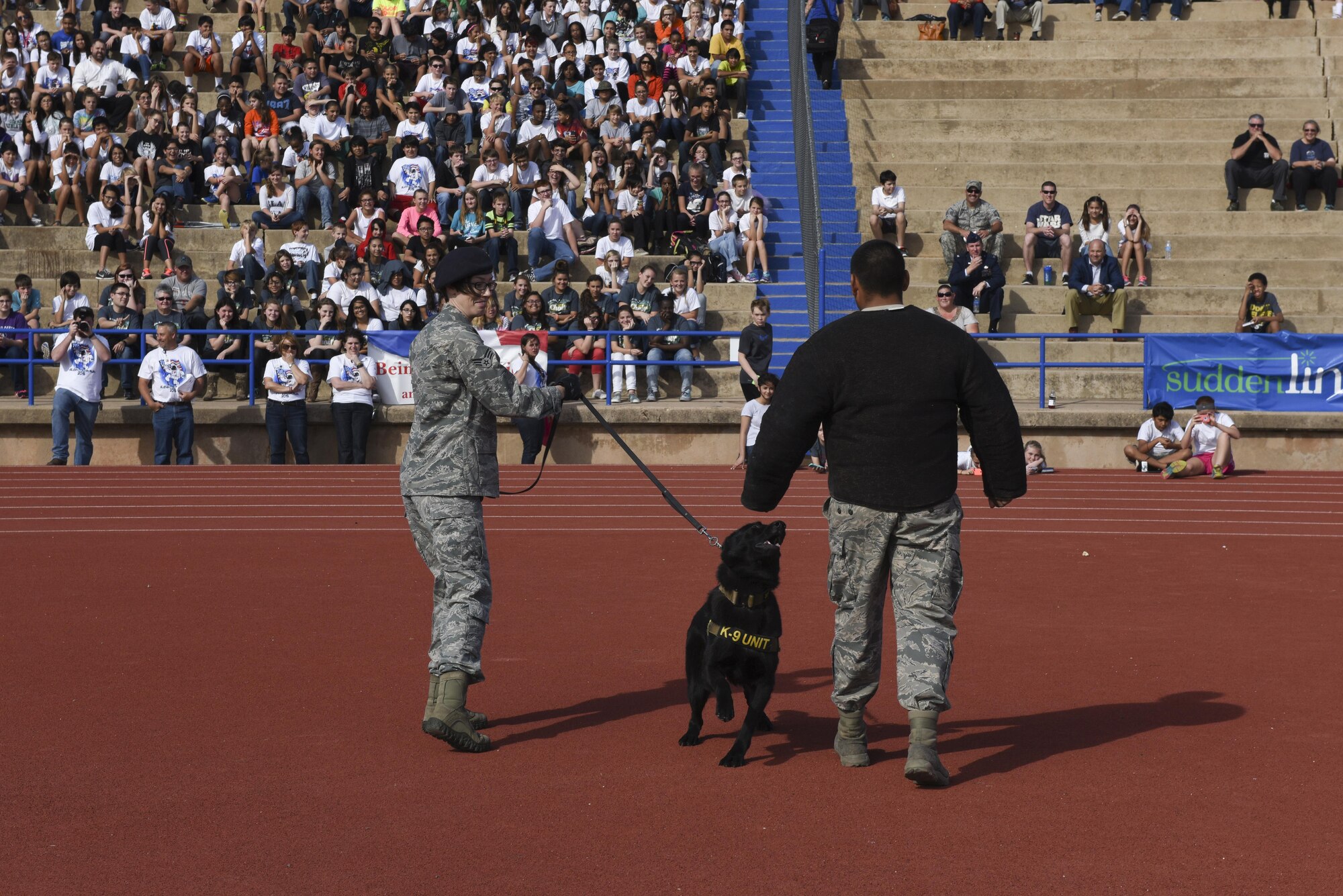 U.S. Air Force Airmen from the 17th Security Forces Squadron show their K-9’s abilities during the Take a Veteran to School event at the San Angelo Stadium in San Angelo, Texas, Nov. 11, 2015. The stunt was a demonstration to show spectators the capabilities of the K-9. (U.S. Air Force photo by Airman Chase Sousa/Released)