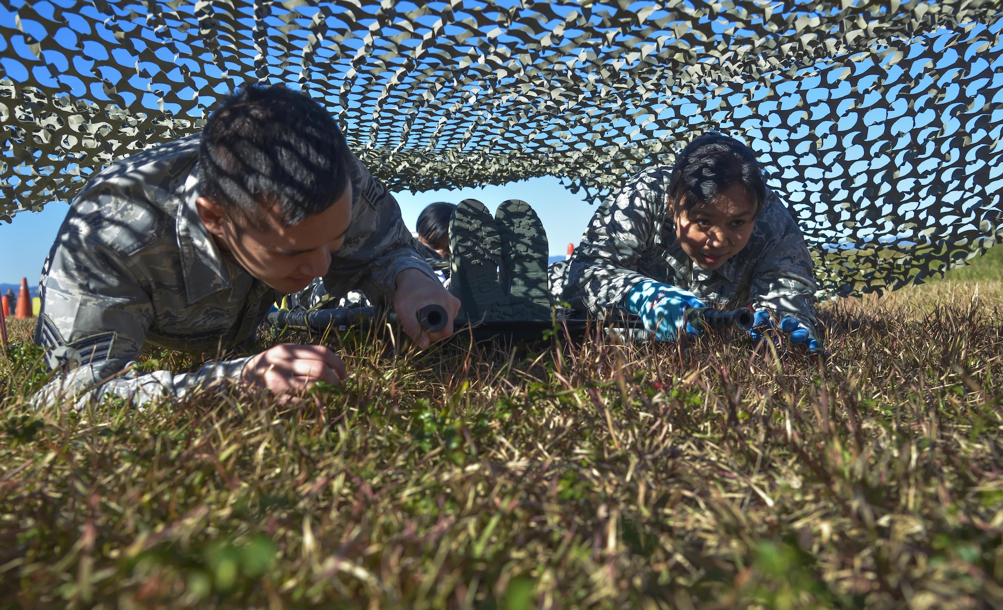 Airmen from the 374th Medical Group low crawl with a patient litter through an obstacle course during a medical evacuation training scenario at Yokota Air Base, Japan, Nov. 4, 2015. The medical evacuation training was completed as part of the Samurai Readiness Inspection being conducted in conjunction with the wing’s participation in exercise Vigilant Ace 16, a U.S. and South Korea combined exercise aimed at enhancing operational and tactical level coordination through combined and joint combat training. (U.S. Air Force photo/Senior Airman David Owsianka)