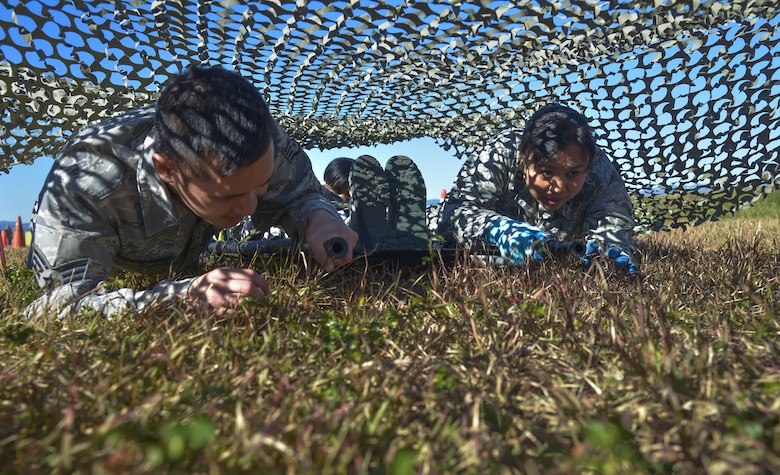 Airmen from the 374th Medical Group low crawl with a patient litter through an obstacle course during a medical evacuation training scenario at Yokota Air Base, Japan, Nov. 4, 2015. The medical evacuation training was completed as part of the Samurai Readiness Inspection being conducted in conjunction with the wing’s participation in exercise Vigilant Ace 16, a U.S. and South Korea combined exercise aimed at enhancing operational and tactical level coordination through combined and joint combat training. (U.S. Air Force photo/Senior Airman David Owsianka)