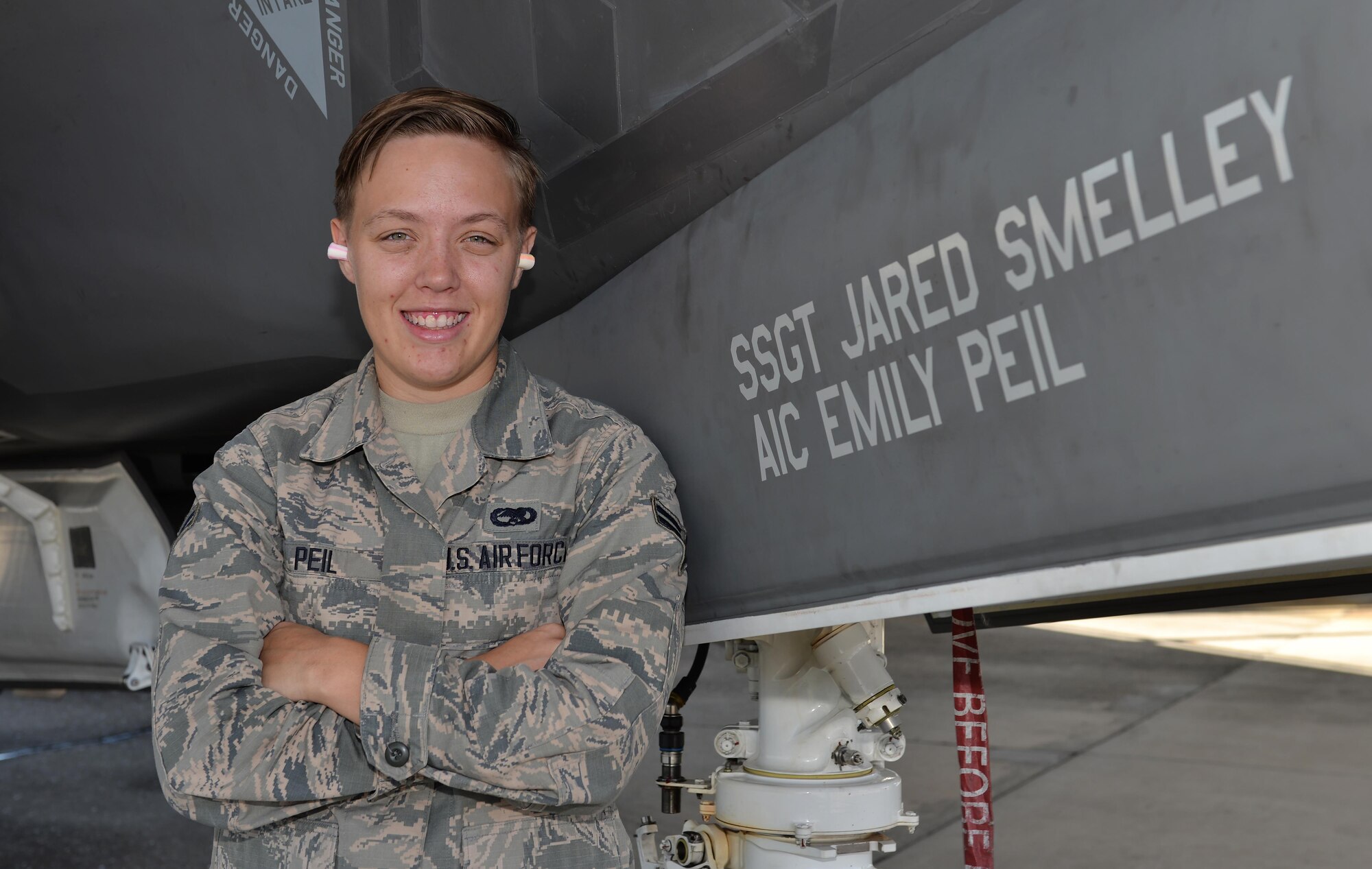 Airman 1st Class Emily Peil, 33rd Aircraft Maintenance Squadron crew chief, stands with the jet that bears her name at Eglin Air Force Base, Fla., Oct. 8, 2015. Peil is one of the first crew chiefs to begin her career on the fifth generation F-35A Lightning II straight from technical school. (U.S. Air Force Photo/Senior Airman Andrea Posey)