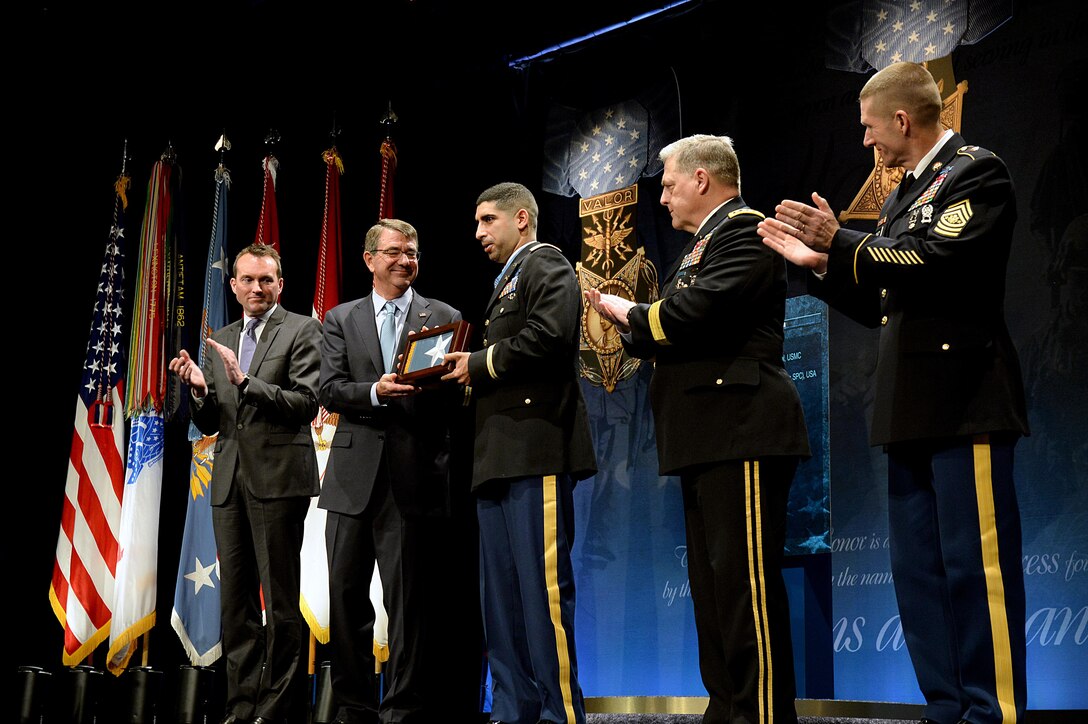 Defense Secretary Ash Carter presents retired Army Capt. Florent A. Groberg with a flag during the Medal of Honor Hall of Heroes induction ceremony at the Pentagon, Nov. 13, 2015. Acting Undersecretary of the Army Eric Kenneth Fanning, left, Army Chief of Staff Gen. Mark A. Milley, second from right, and Sgt. Maj. of the Army Daniel A. Dailey participated in the ceremony. DoD photo by Army Sgt. 1st Class Clydell Kinchen