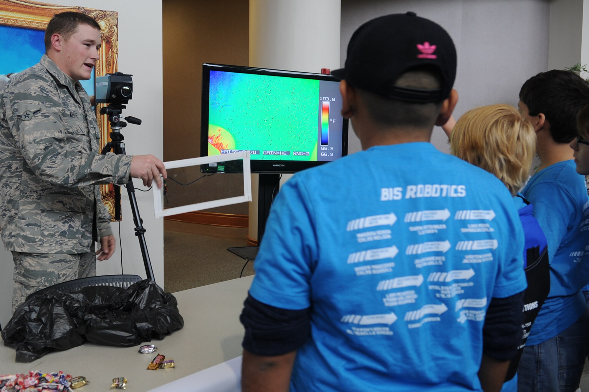 Airman Paul E. White, 312th Training Squadron Special Instruments Training student, demonstrates to youth how Plexiglas blocks heat from the infrared camera during the Texas Computer Education Association Area 15 Robotics Competition at Angelo State University in San Angelo, Texas, Nov. 9, 2015. The 312th TRS instructors used the demonstration as a training exercise for their students. (U.S. Air Force photo by Staff Sgt. Laura R. McFarlane/Released)