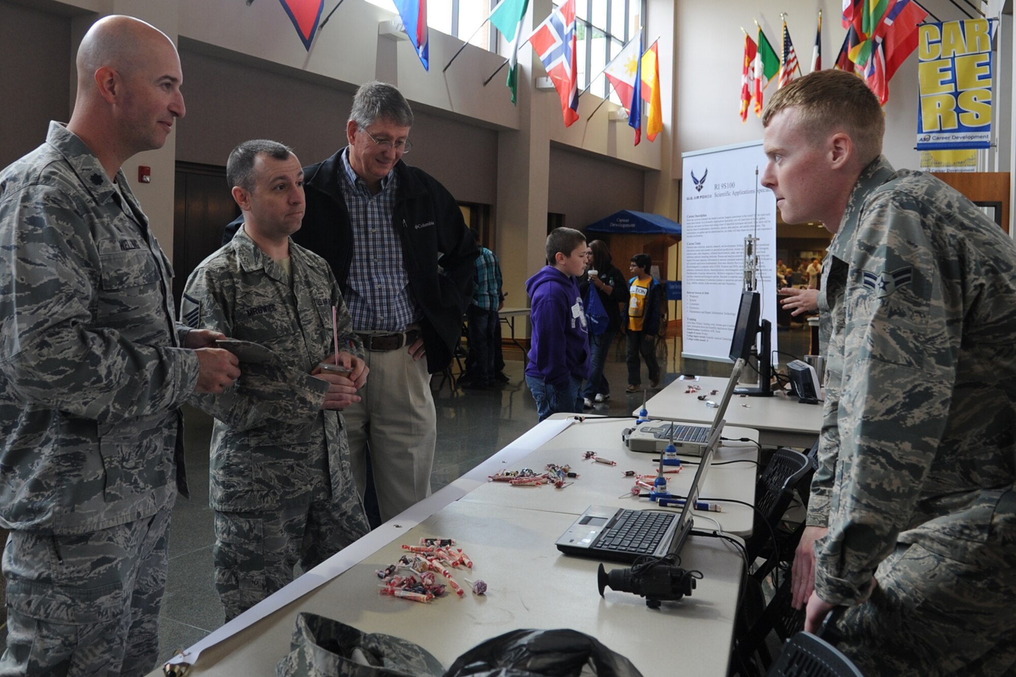 Airman 1st Class Cody L. Eischeid, 312th Training Squadron Special Instruments Training student, briefs Lt. Col. Matthew D. Welling, 312th TRS commander, on SPINSTRA instruments used during the Texas Computer Education Association Area 15 Robotics Competition at Angelo State University in San Angelo, Texas, Nov. 9, 2015. Members of the 312th TRS SPINSTRA flight provided demonstrations of the science, technology, engineering, and mathematics aspects of their career fields to attendees of the competition. (U.S. Air Force photo by Staff Sgt. Laura R. McFarlane/Released)