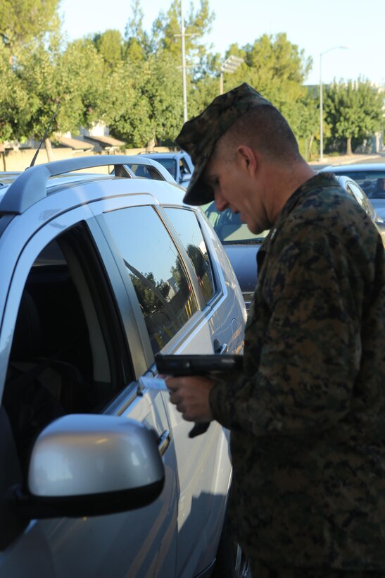 Col. Jason Woodworth, commanding officer of Marine Corps Air Station Miramar, checks identification cards at the North gate aboard MCAS Miramar, Calif., Nov. 13. Every service member and Department of Defense employee has a common access card they must show to gain access to the base.