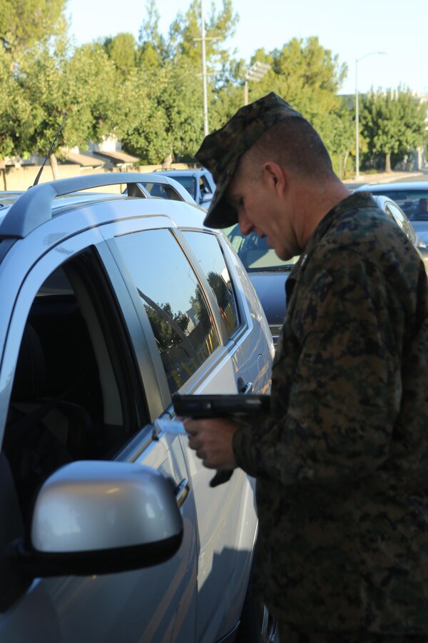 Col. Jason Woodworth, commanding officer of Marine Corps Air Station Miramar, checks identification cards at the North gate aboard MCAS Miramar, Calif., Nov. 13. Every service member and Department of Defense employee has a common access card they must show to gain access to the base.