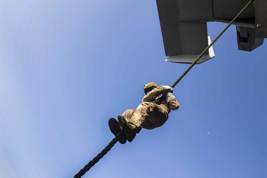 A U.S. Marine conducts a static fast-rope drill aboard the amphibious assault ship USS Kearsarge in the North Red Sea, Nov. 3, 2015. The Marine is assigned to Weapons Company, Battalion Landing Team, 2nd Battalion, 6th Marine Regiment, 26th Marine Expeditionary Unit. The unit is embarked on the Kearsarge, which is maintaining regional security in the U.S. 5th Fleet area of operations. U.S. Marine Corps photo by Cpl. Jalen D. Phillips