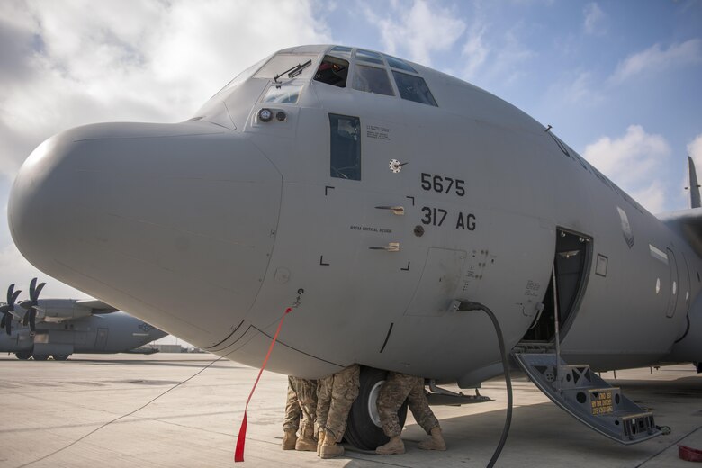 Airmen deployed from Dyess Air Force Base, Texas, examine a nose armor saddle bracket near the landing gear of a C-130 Hercules at Bagram Airfield, Afghanistan, Nov. 13, 2015. The 455th EAMXS is responsible for repairing and maintaining military aircraft on Bagram, as well as performing preventative maintenance inspections. (U.S. Air Force photo/Tech. Sgt. Robert Cloys/RELEASED)