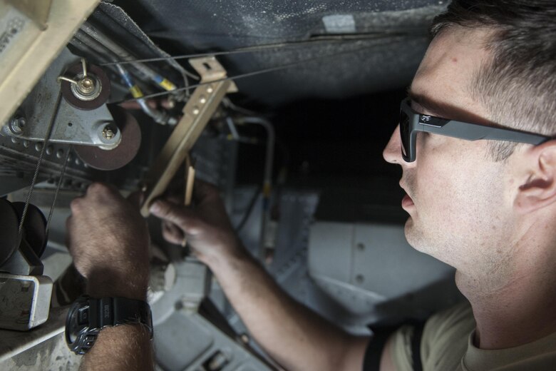 Senior Airman Zach Quinn, 455th Expeditionary Aircraft Maintenance Squadron crew chief, deployed from Dyess Air Force Base, Texas, removes a nose armor saddle bracket near the front landing gear of a C-130 Hercules at Bagram Airfield, Afghanistan, Nov. 13, 2015. The 455th EAMXS is responsible for repairing and maintaining military aircraft on Bagram, as well as performing preventative maintenance inspections. (U.S. Air Force photo/Tech. Sgt. Robert Cloys/RELEASED)