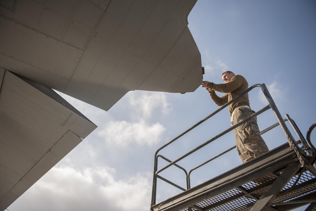 Senior Airman Nick Orchard, 455th Expeditionary Aircraft Maintenance Squadron crew chief, deployed from Dyess Air Force Base, Texas, replaces a navigation light on a C-130 Hercules at Bagram Airfield, Afghanistan, Nov. 13, 2015. The 455th EAMXS is responsible for repairing and maintaining military aircraft on Bagram, as well as performing preventative maintenance inspections. (U.S. Air Force photo/Tech. Sgt. Robert Cloys/RELEASED)