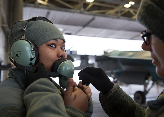 U.S. Air Force Senior Airman Diamond Thompson, a 354th Medical Operations Squadron public health technician, dons a communication headset before an F-16 Fighting Falcon aircraft launch from the 18th Aggressor Squadron hangars Nov. 6, 2015, at Eielson Air Force Base, Alaska. Thompson participated in a new incentive program for quarterly award winners allowing Airmen to participate in jet launches alongside crew chiefs. (U.S. Air Force photo by Senior Airman Peter Reft/Released)