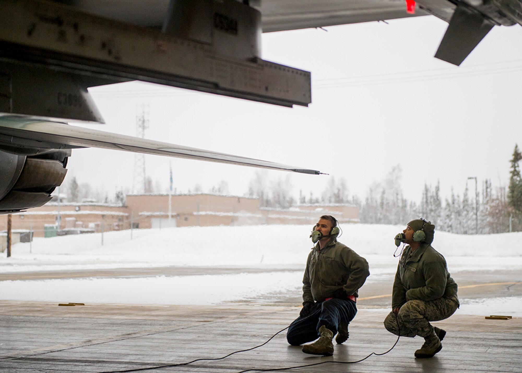 U.S. Air Force Senior Airman Andrew Ropp, a 354th Aircraft Maintenance Squadron F-16 Fighting Falcon aircraft crew chief, prepares an F-16 for launch, while Senior Airman Diamond Thompson, a 354th Medical Operations Squadron public health technician, follows and watches the procedure Nov. 6, 2015, at Eielson Air Force Base, Alaska. Thompson participated in a new incentive program for quarterly award winners allowing Airmen to participate in jet launches alongside crew chiefs. (U.S. Air Force photo by Senior Airman Peter Reft/Released)