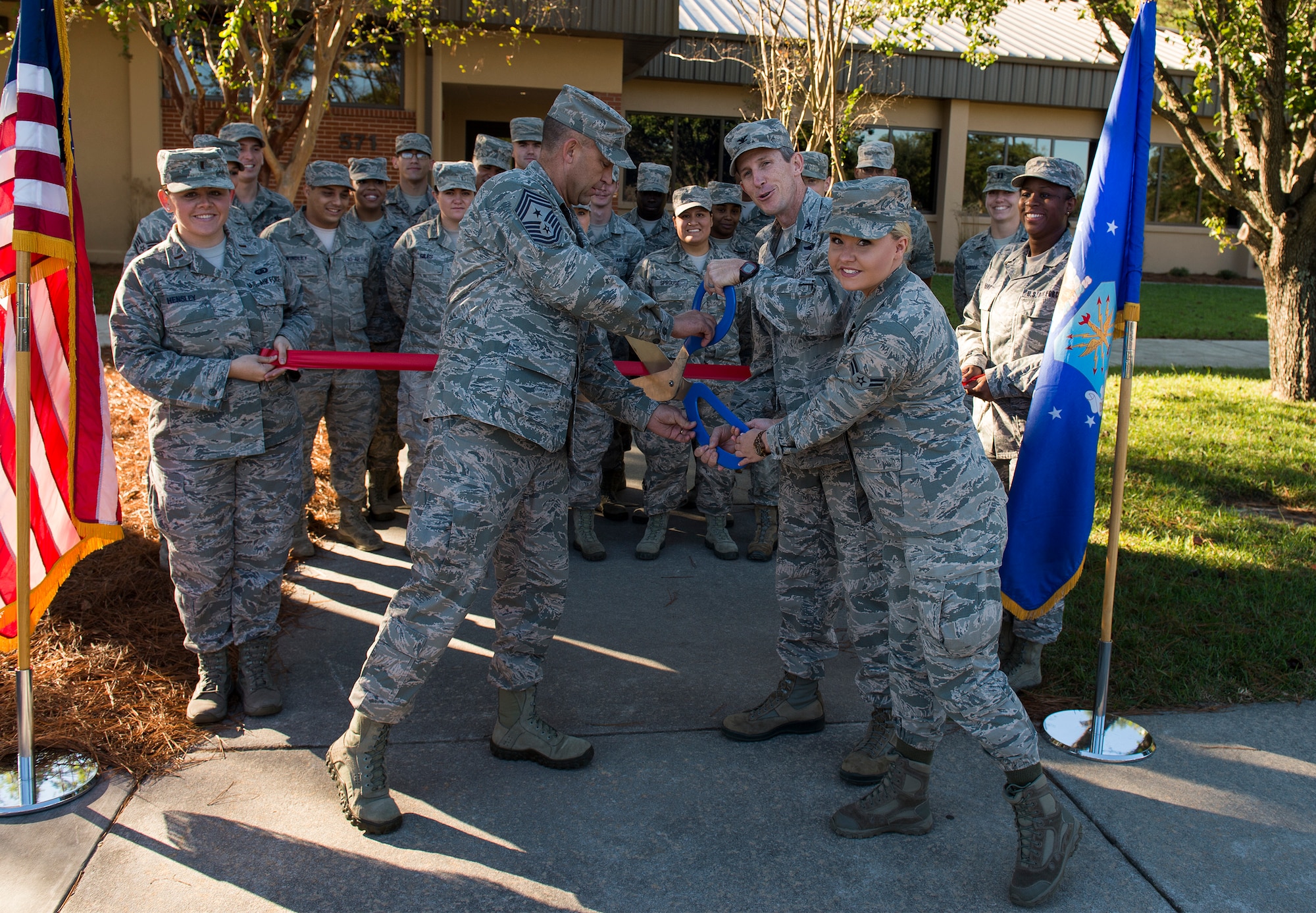 Col. Thomas Kunkel and Chief Master Sgt. David Kelch, 23d Wing commander and command chief, cut a ribbon with Airman 1st Class Ardella Tharpe, 23d Force Support Squadron services apprentice, during the Georgia Pines Dining Facility ribbon cutting ceremony, Nov. 13, 2015, at Moody Air Force Base, Ga. The renovated dining facility will serve its first meal Sunday, Nov. 15. (U.S. Air Force photo/Tech. Sgt. Zachary Wolf)