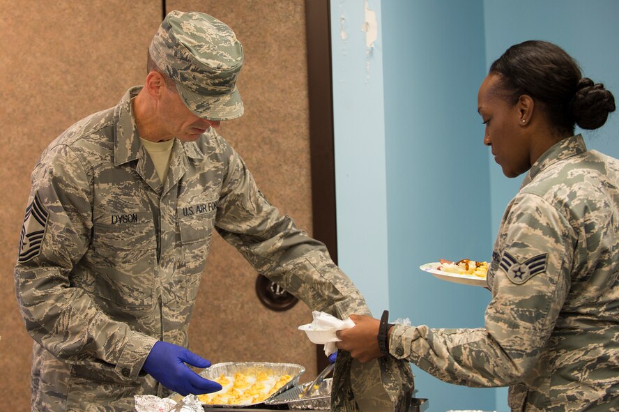 U.S. Air Force Chief Master Sgt. Edward Dyson, 336th Recruiting Squadron superintendent, serves Senior Airman Karla Davis, 23d Comptroller Squadron in-processing technician, food during the Airmen’s Thanksgiving Luncheon, Nov. 13, 2015, at Moody Air Force Base, Ga. Dyson said the event, which gave the Airmen a sense of having a home away from home with their new Air Force family, was a success. (U.S. Air Force photo by Senior Airman Ceaira Tinsley/Released)