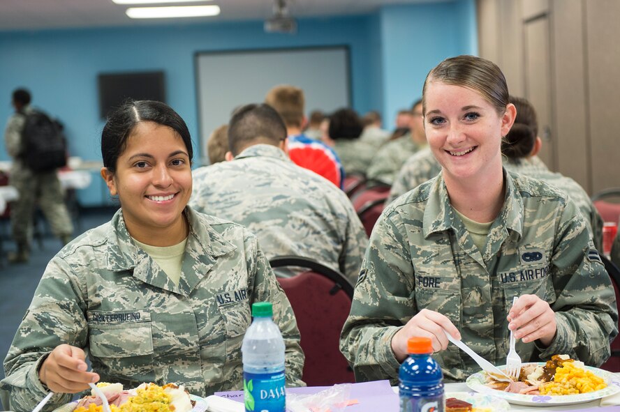U.S. Air Force Airman Diana Garcia-Ferrufino, (left), and Airman 1st Class Brittany Fore, 23d Equipment Maintenance Squadron nondestructive inspection apprentices, pause from their meal to pose for a photo during the Airmen’s Thanksgiving Luncheon, Nov. 13, 2015, at Moody Air Force Base, Ga. Garcia-Ferrufino and Fore echoed that they appreciated the organizations who helped provide this event for Airmen on base. Garcia-Ferrufino said she misses helping her mom cook Thanksgiving dinner and Fore stated she misses spending time with her cousins. (U.S. Air Force photo by Senior Airman Ceaira Tinsley/Released)