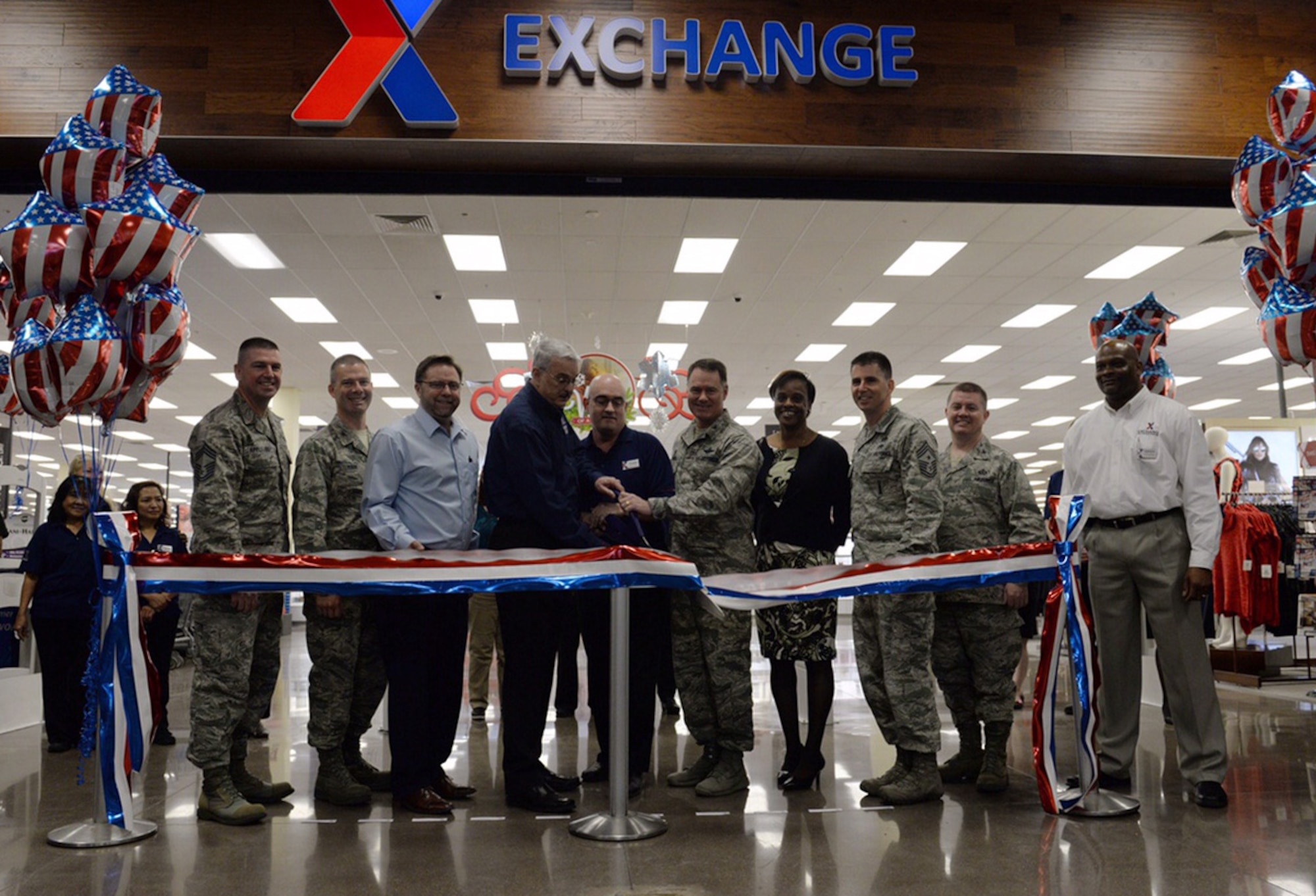 Members of Nellis Air Force Base, Nev., and the Army & Air Force Exchange Service celebrate the Exchange grand opening by cutting the grand opening ribbon during a ceremony held Nov. 10, 2015. Military shoppers can experience a whole new shopping experience inside the newly-renovated Exchange. (U.S. Air Force photo by Airman 1st Class Rachel Loftis) 