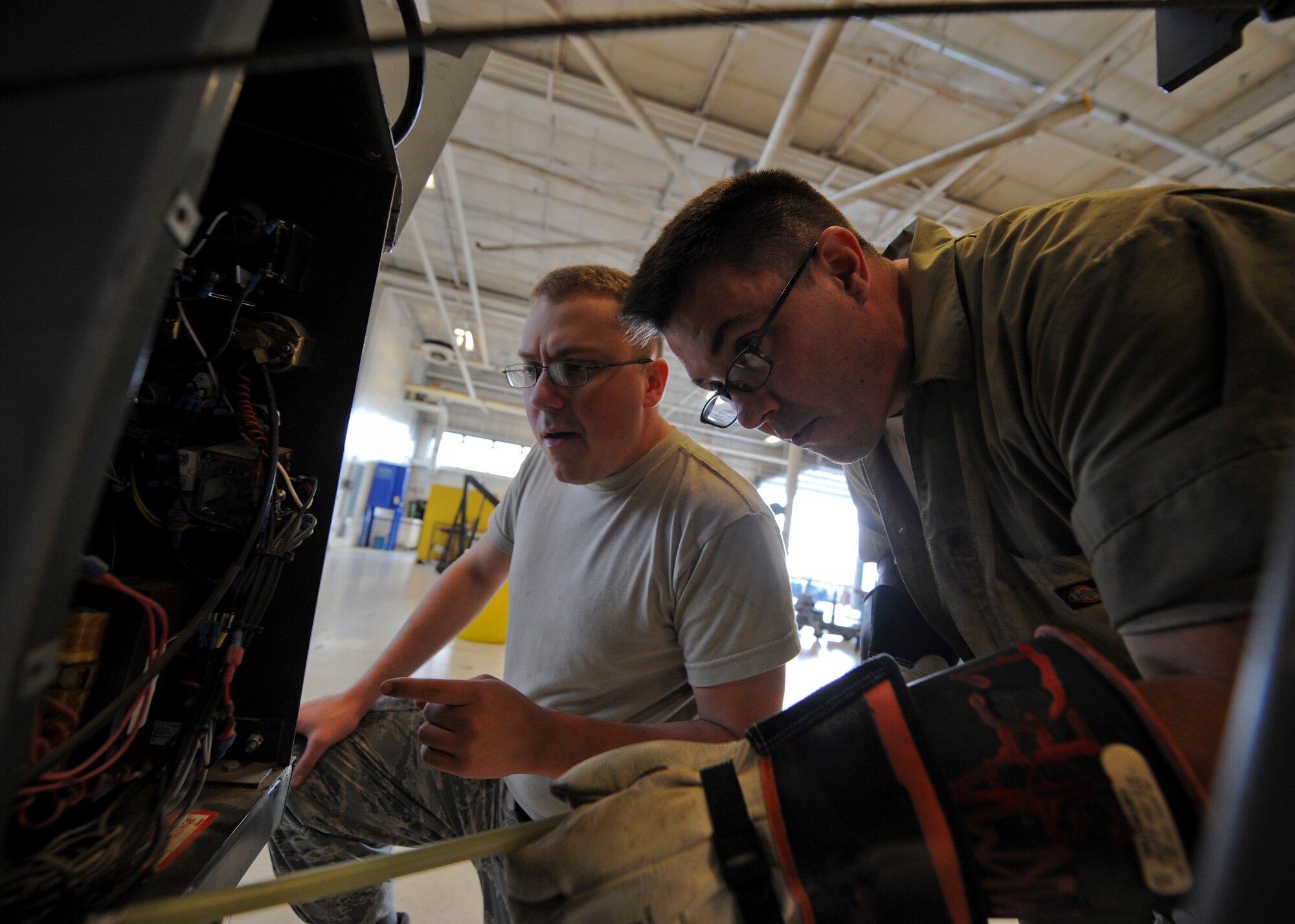 Senior Airmen James Copeland, left, and Joshua Farr, 22nd Maintenance Squadron aerospace ground equipment flight journeymen, check the voltage of a capacitor in a flood light cart, Nov. 5, 2015, at McConnell Air Force Base, Kan. The AGE flight provides the rest of the 22nd Maintenance Group with the equipment needed to troubleshoot any issues on the KC-135 Stratotanker that requires power or heating while on the ground. (U.S. Air Force photo/Senior Airman Victor J. Caputo)
