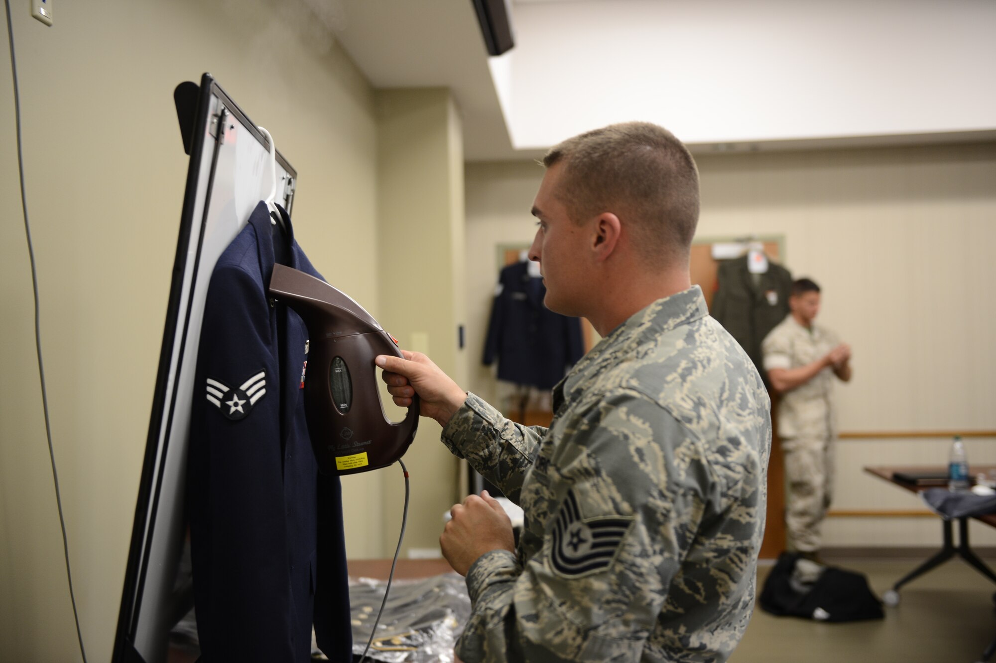 Tech. Sgt. Tyler Seeholzer, 421st Combat Training Squadron, prepares his service dress uniform before a board appearance May 15, 2015 at Joint Base McGuire-Dix-Lakehurst, N.J. Beginning Nov. 18, 2015, 87th Air Base Wing service members will be required to wear their blues or service equivalent uniform every Wednesday. (U.S. Air Force by Staff Sgt. Katherine Tereyama)
