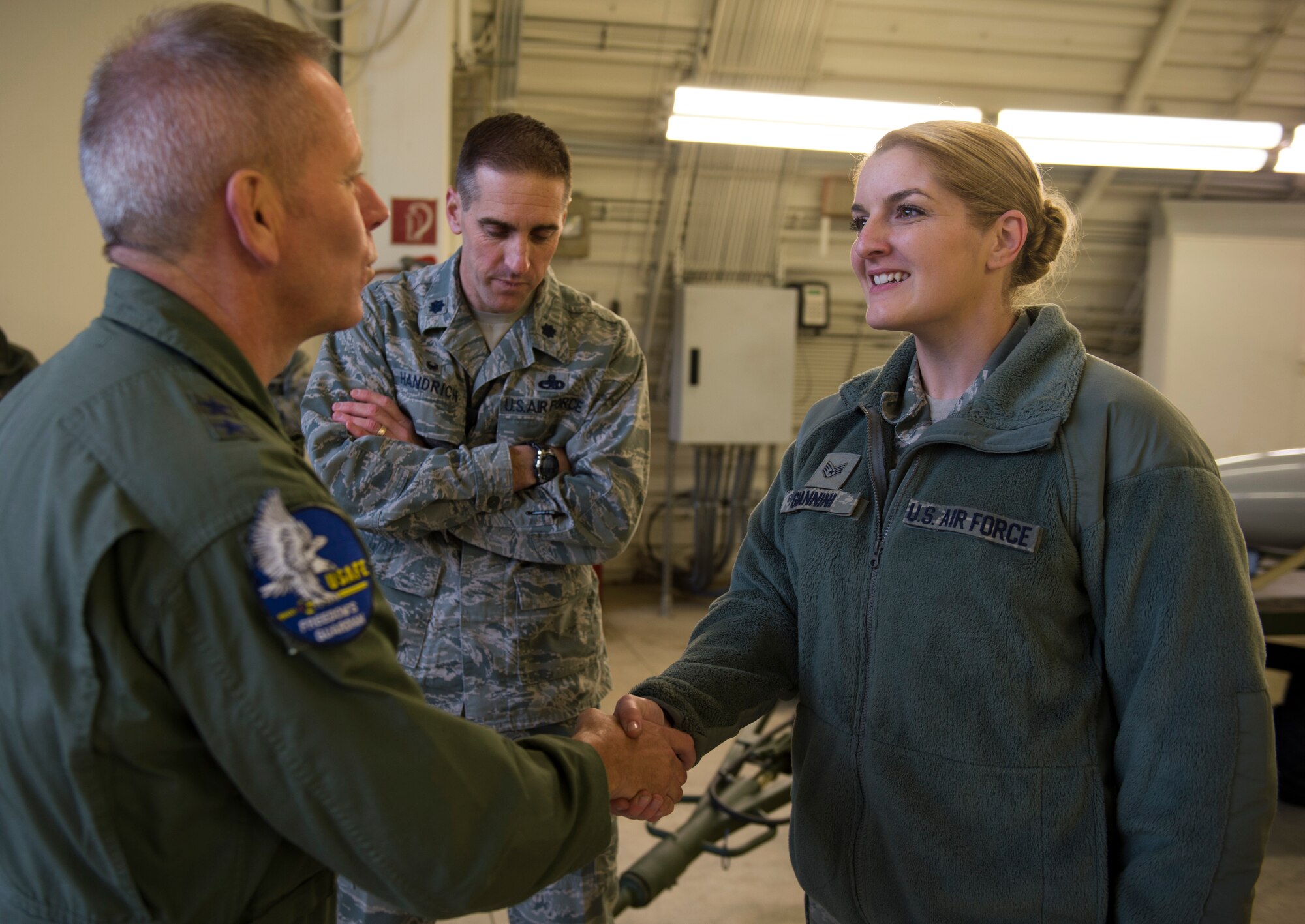 U.S. Air Force Maj. Gen. John McMullen, U.S. Air Forces in Europe and Air Forces Africa Strategic Deterrence Integration director of operations, presents a coin to U.S. Air Force Master Sgt. Randee Giannini, a 702nd Munitions Support Squadron  NCO in charge accountability and reporting, during a tour of 702nd MUNSS at Buechel Air Base, Germany, Nov. 10, 2015. The 702nd MUNSS is divided into five flights consisting of the maintenance, operations, communications, custody and force support. The squadron directly supports NATO contingency and wartime operations and its strike mission. (U.S. Air Force photo by Staff Sgt. Christopher Ruano/Released)