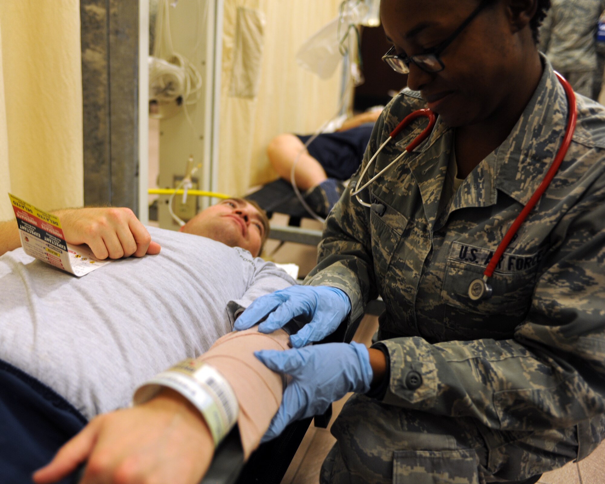 Staff Sgt. Jade Hood, 39th Medical Operations Squadron immunization technician, treats Staff Sgt. Iram Blanco, 39th MDOS mental health technician, who has a simulated arm injury during an exercise Oct. 28, 2015, at Incirlik Air Base, Turkey. Blanco went through an entire decontamination treatment and medical process during the exercise. (U.S. Air Force photo by Airman 1st Class Daniel Lile/Released)