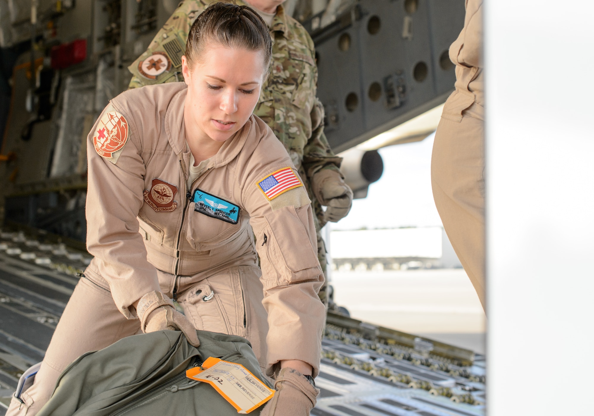 Senior Airman Beverly Spencer, 10th Expeditionary Aeromedical Evacuation Flight technician, loads a bag onto a C-17 Globemaster III Nov. 10, 2015, at Ramstein Air Base, Germany. Spencer and a crew of medical professionals departed Ramstein to retrieve and care for injured service members. (U.S. Air Force photo/Staff Sgt. Armando A. Schwier-Morales)