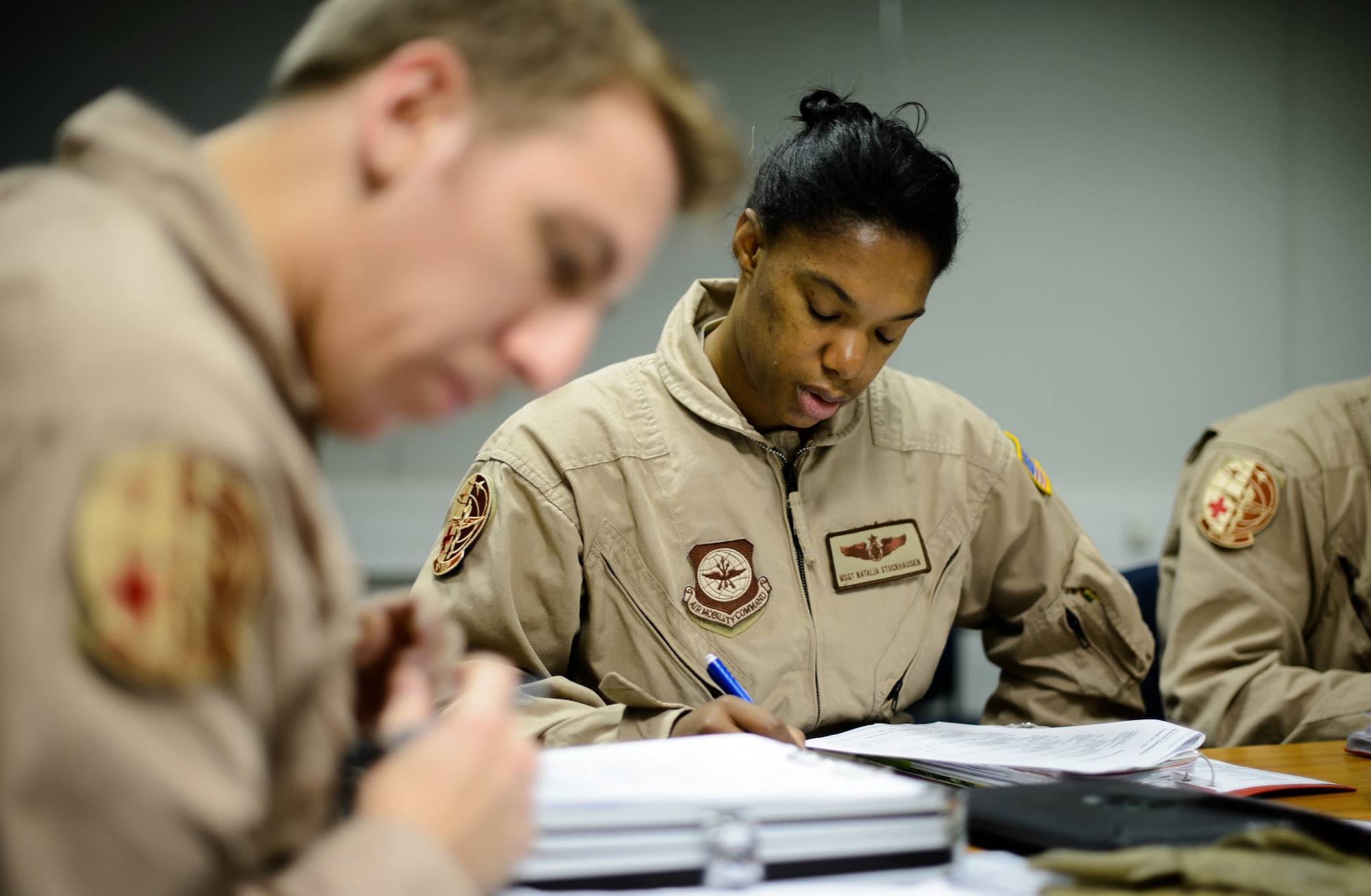Master Sgt. Natalia Stockhausen, center, and Senior Airman Ryan Rieth, both 10th Expeditionary Aeromedical Evacuation Flight technicians, review a patient’s status prior to performing an evacuation flight Nov. 10, 2015, at Ramstein Air Base, Germany. Technicians, nurses and doctors fly constantly to various areas of operation to return patients to hospitals in Germany or the U.S. for further treatment. (U.S. Air Force photo/Staff Sgt. Armando A. Schwier-Morales)