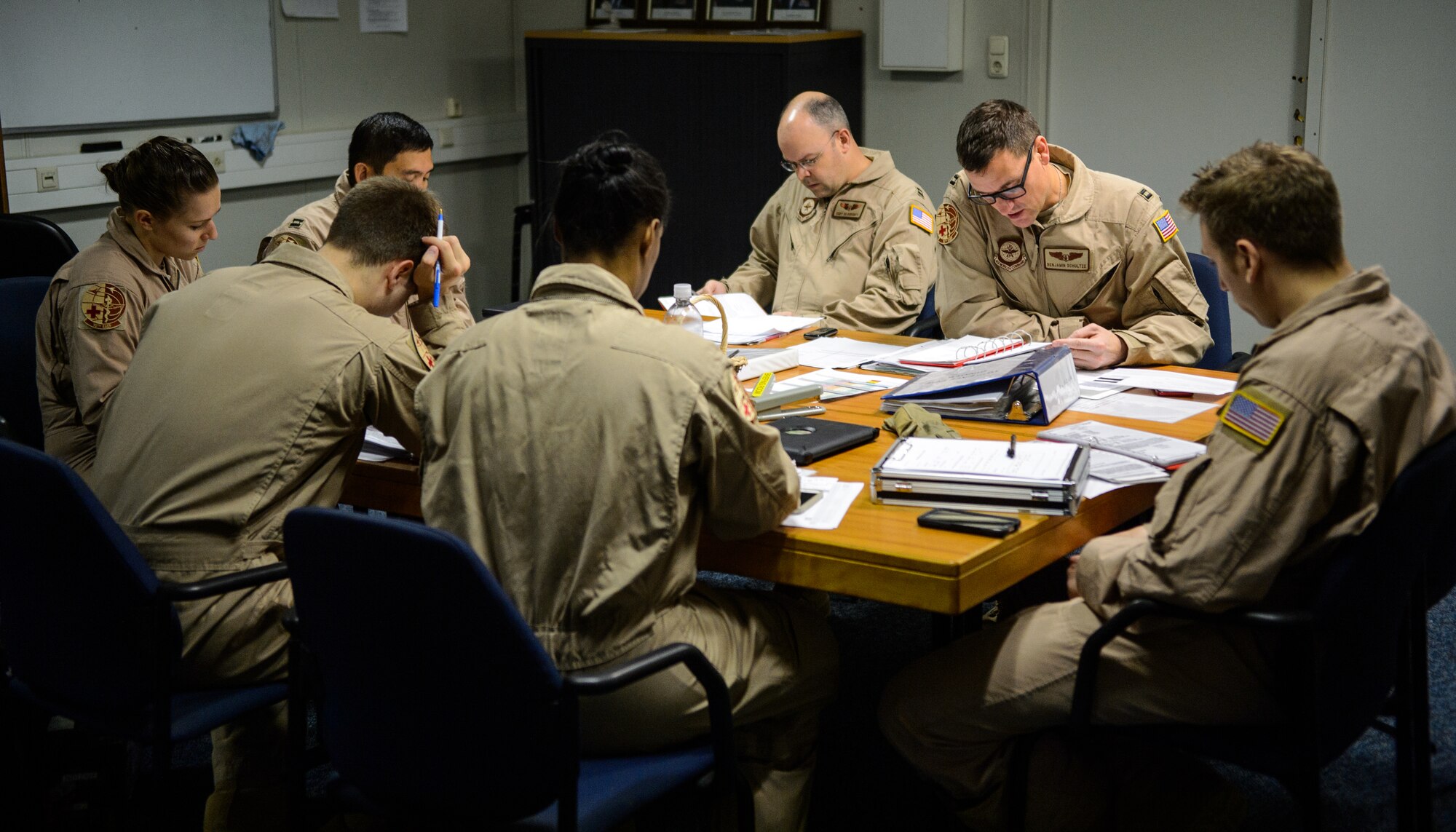 A crew from the 10th Expeditionary Aeromedical Evacuation Flight conducts a pre-mission briefing prior to an evacuation mission Nov. 10, 2015, at Ramstein Air Base, Germany. The crews conduct pre-mission briefings to discuss and understand flight plans, safety operations, necessary supplies, number of patients and their health conditions. (U.S. Air Force photo/Staff Sgt. Armando A. Schwier-Morales)